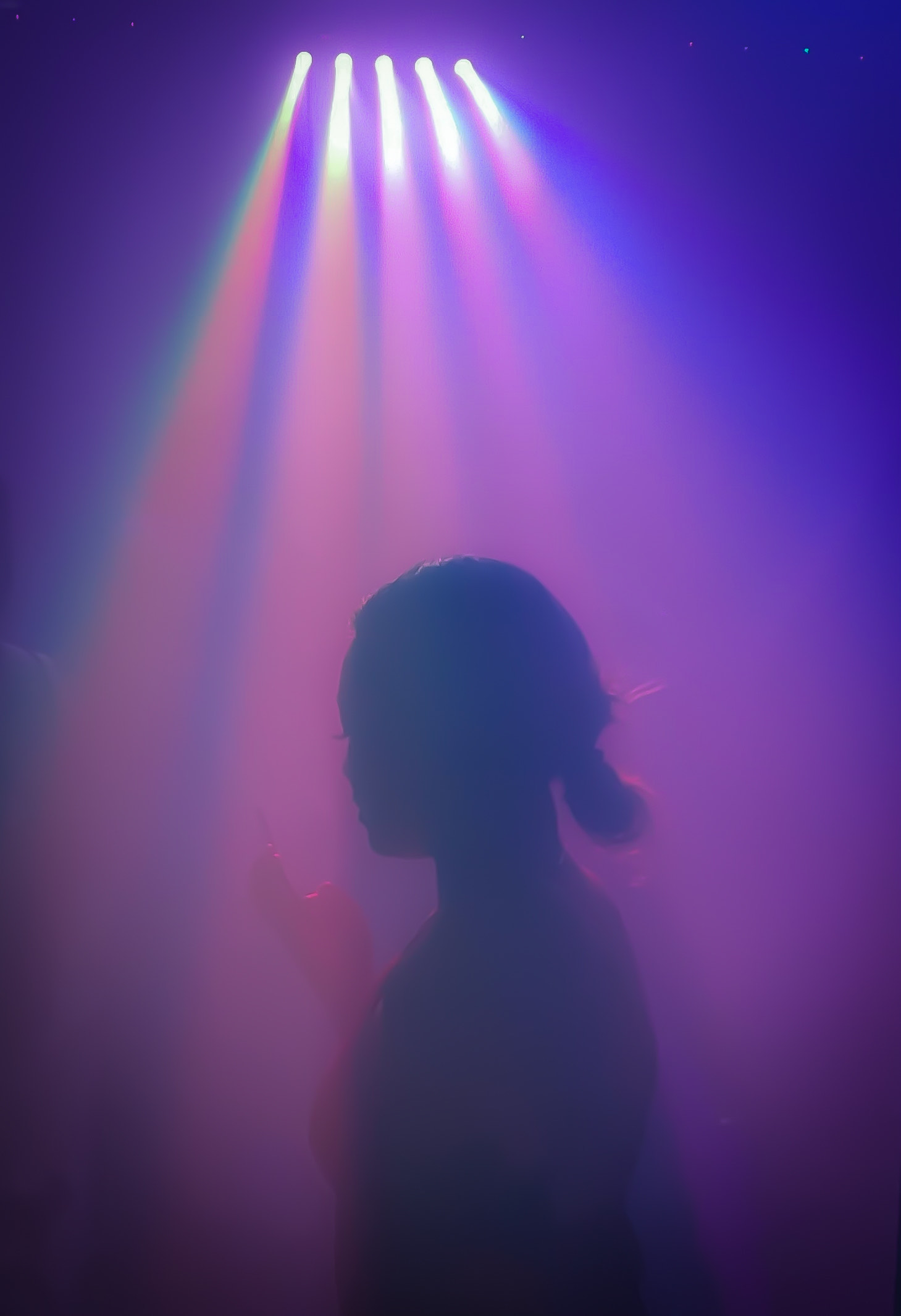 girl standing under the hazy strobe lights in a club