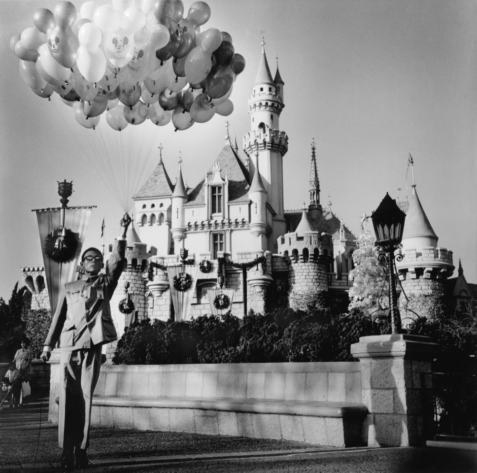 a man in a Zhongshan suit stood in front of the castle in disneyland paris