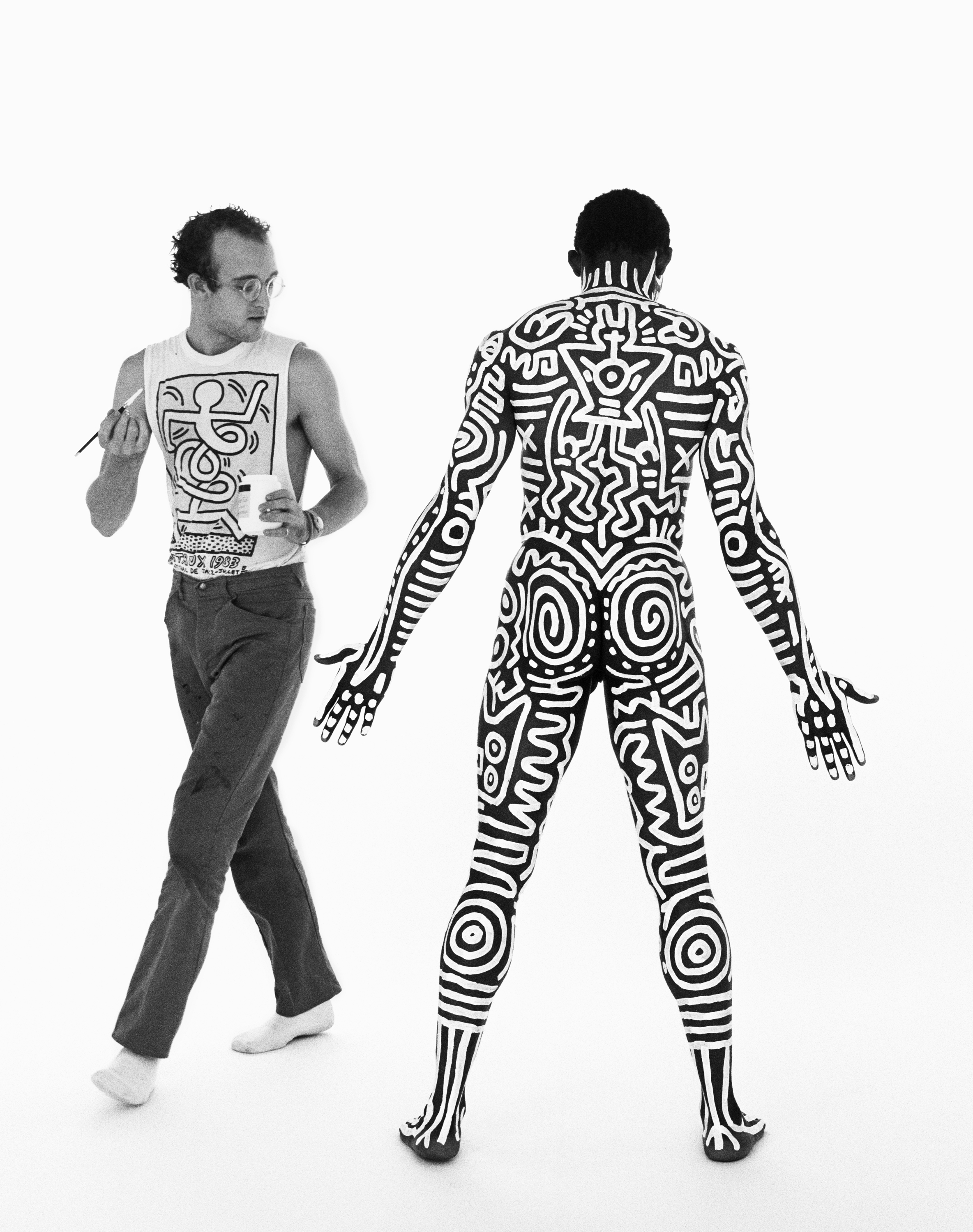 the artist keith haring and a model covered in body paint 