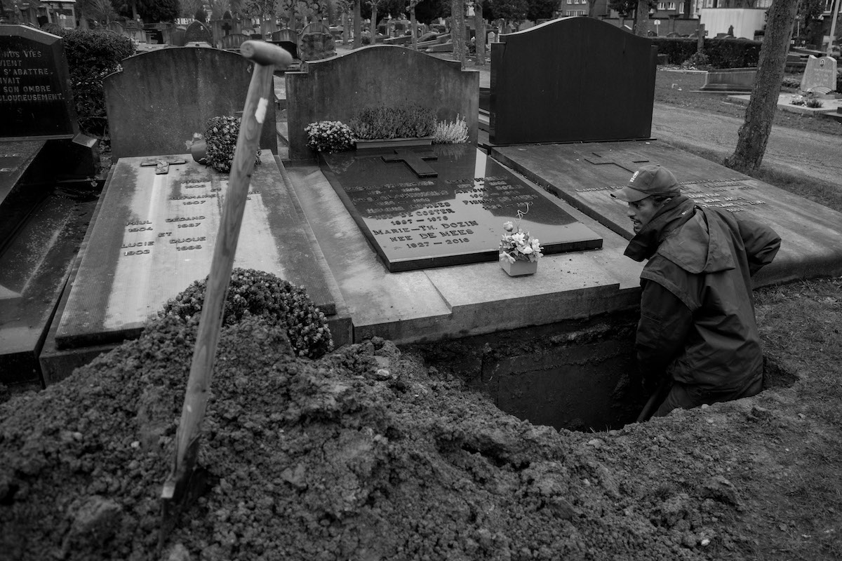 Jacques Vermeer, Patrick, cemetery - Black and white photo of a man digging a grave on a rainy day.