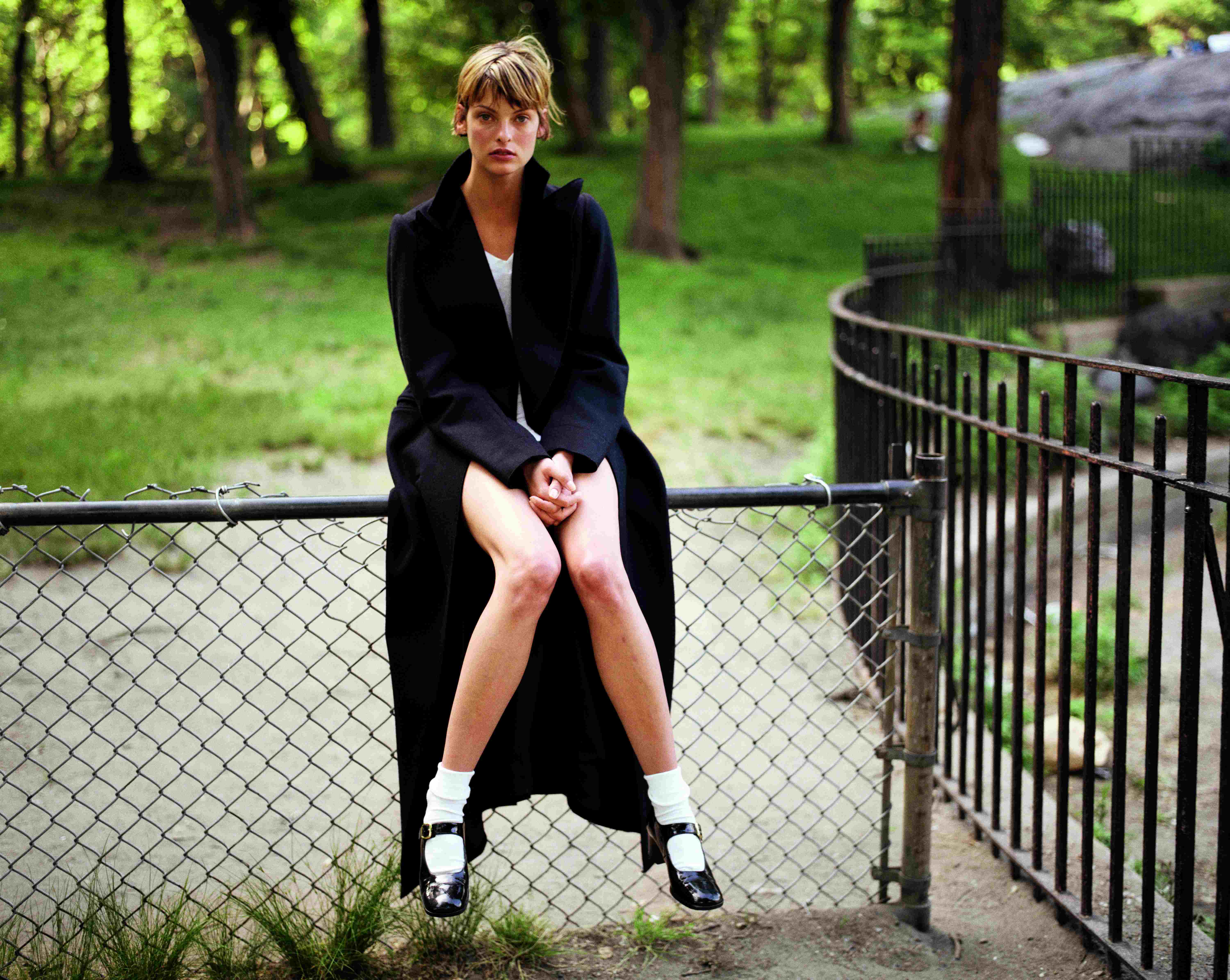 linda evangelista sitting on a fence in central park by juergen teller 1993