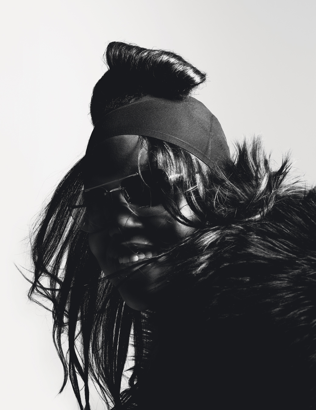 Close up of model wearing black coat and sunglasses