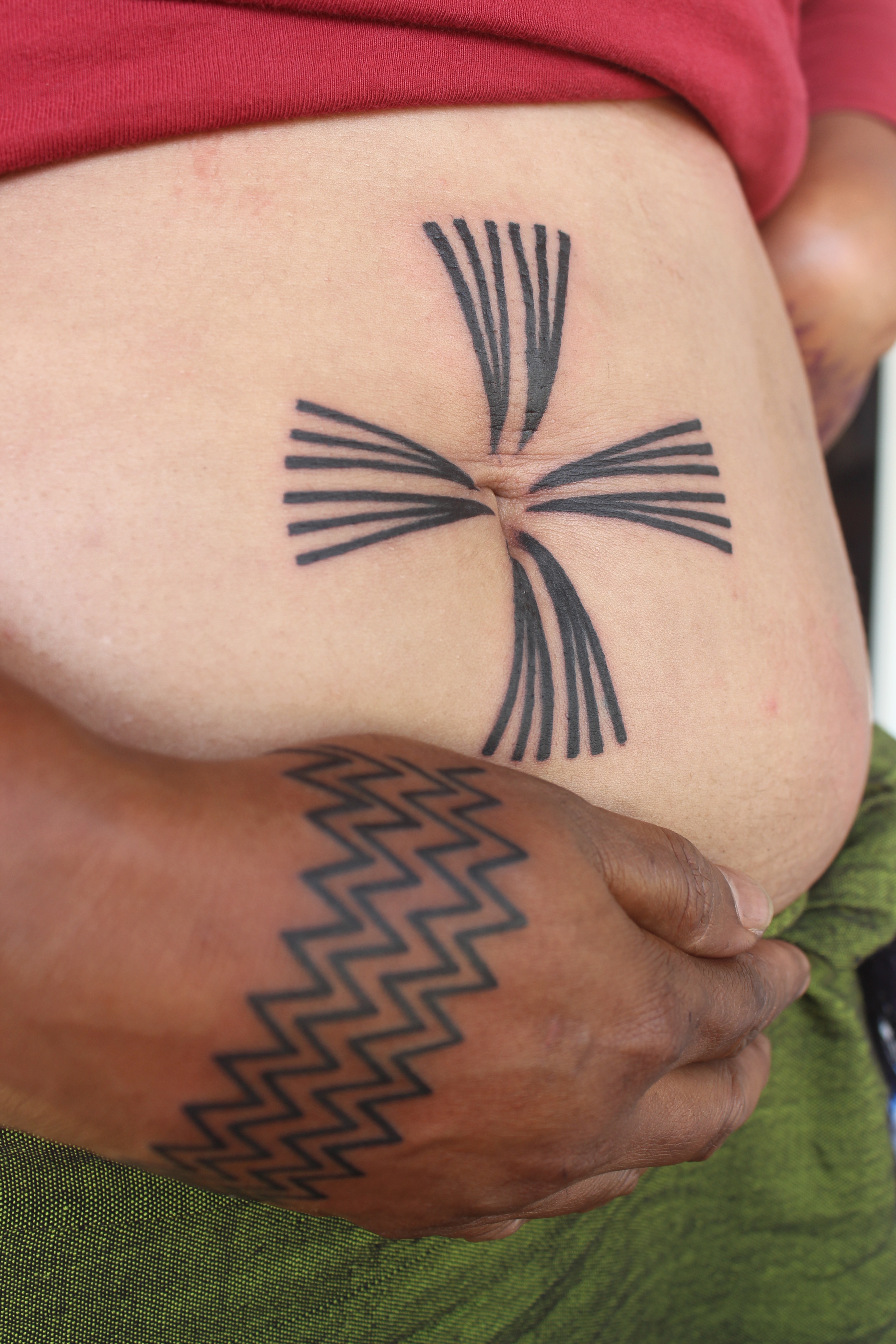 Perempuan Konyak memamerkan tato di badannya.