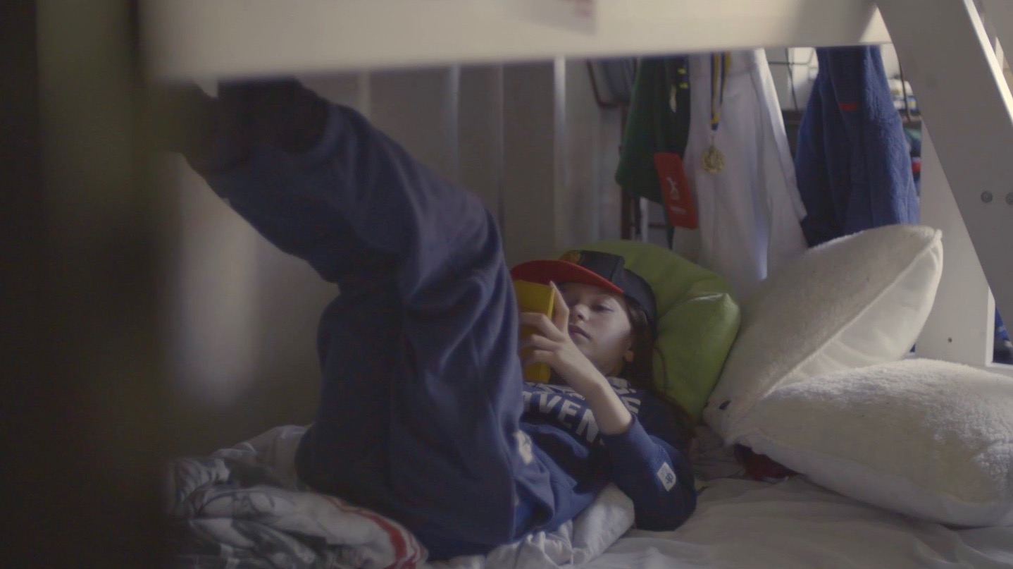 gabi sedut sul letto che gioca con il gameboy