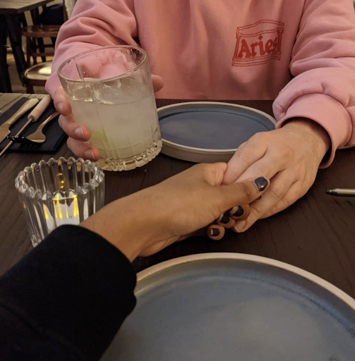 A couple holding hands at dinner
