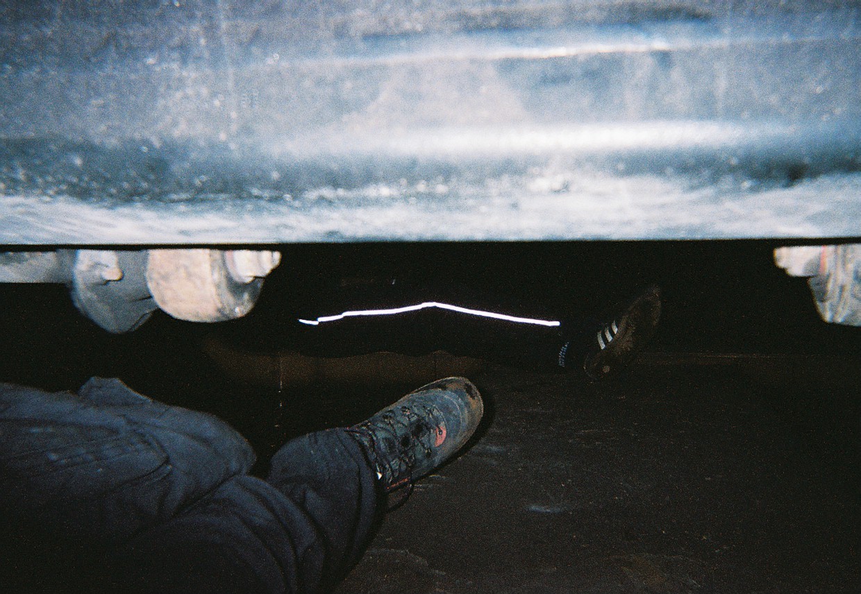Foto kaki seseorang di bawah rel kereta