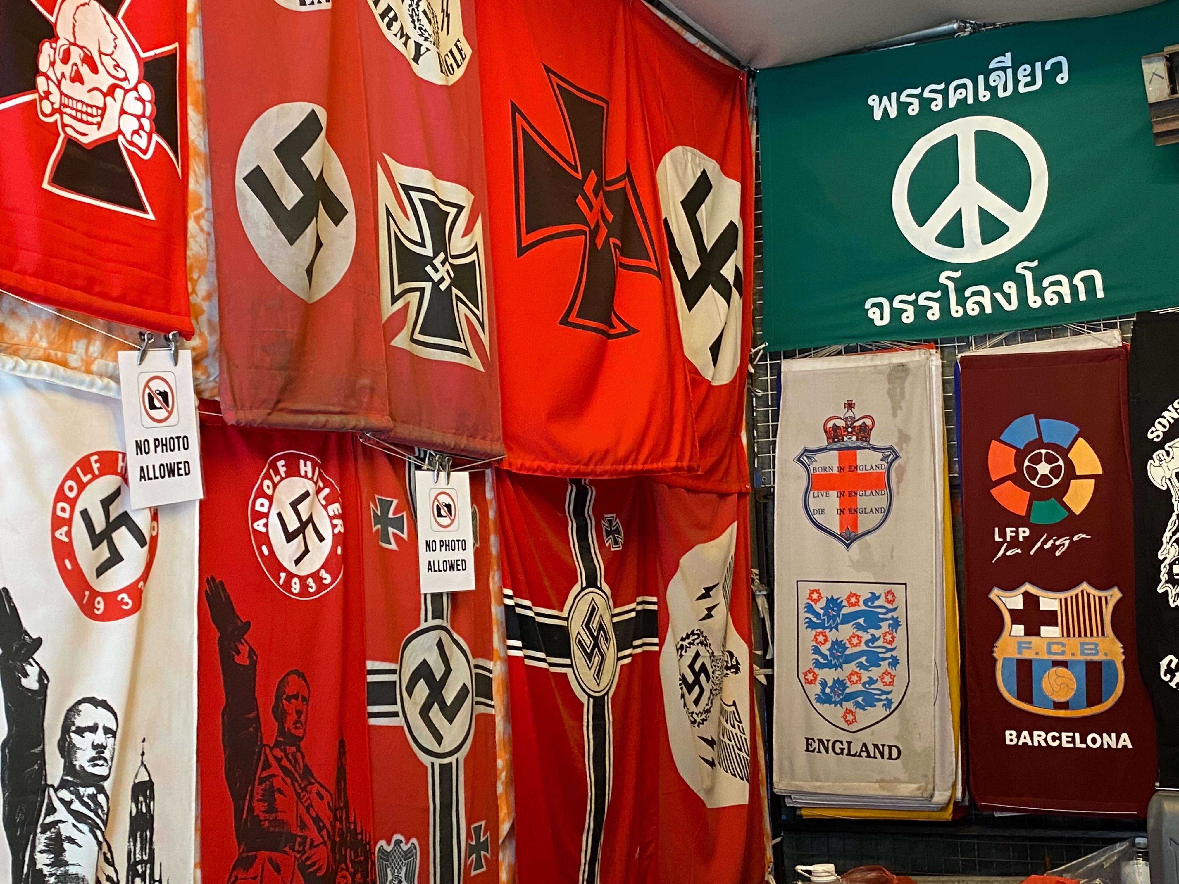 Deretan bendera lambang Nazi dan gambar Hitler memberi hormat
