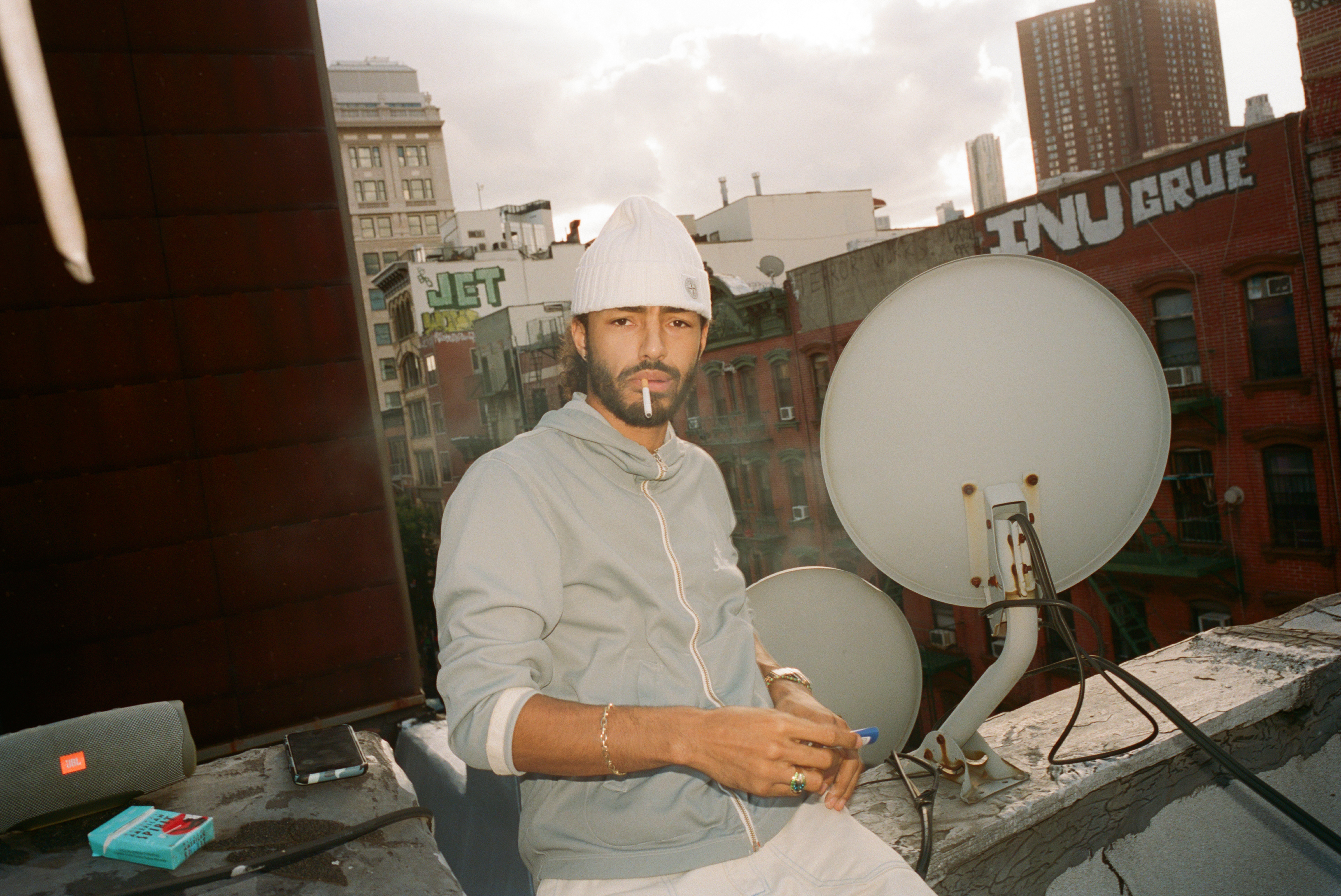 sage elsesser smoking a cigarette on a new york rooftop