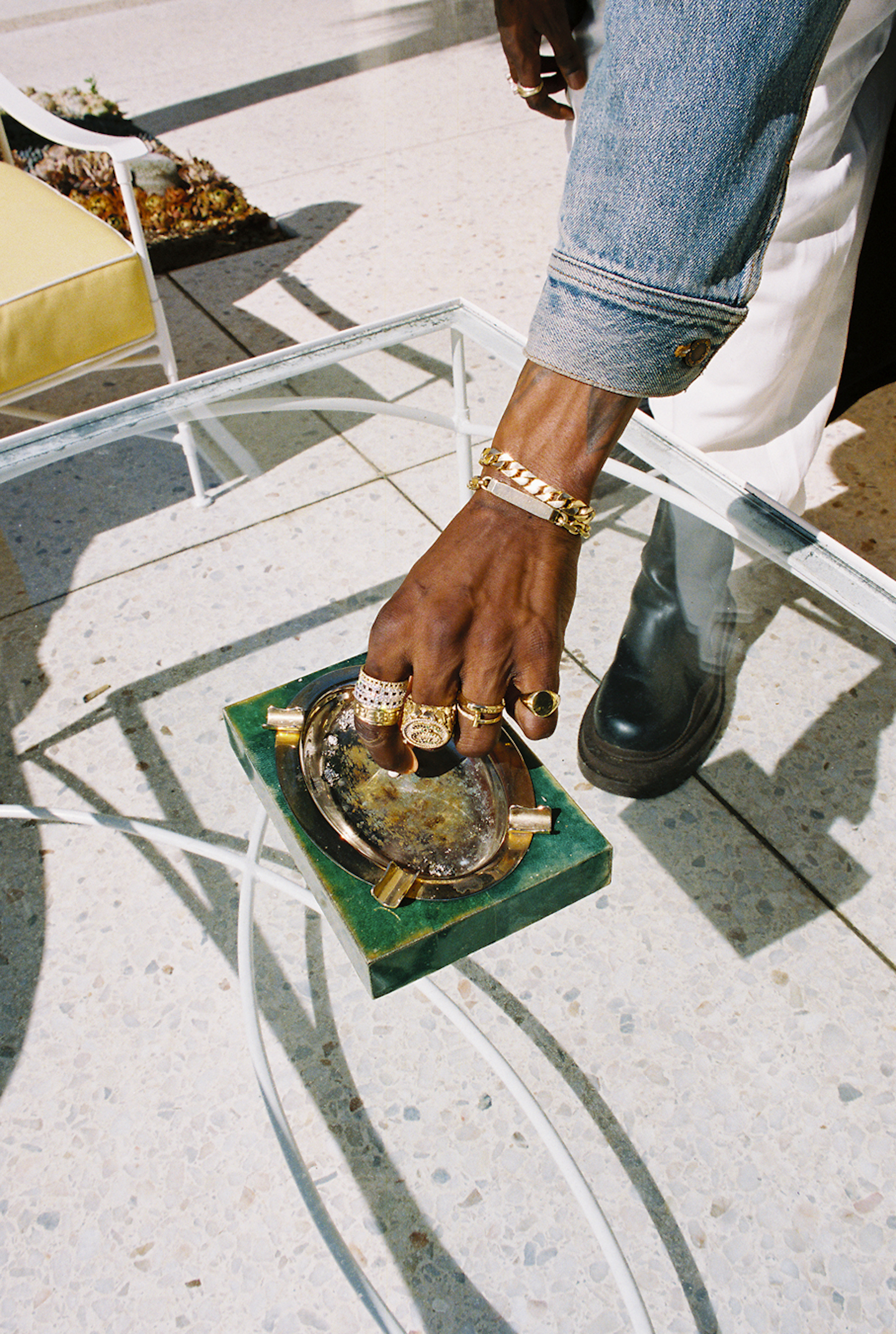 A $ AP Nast's arm reaches down to put out a cigarette on a jade stone gold-plated ashtray photographed by Bladimir Corniel