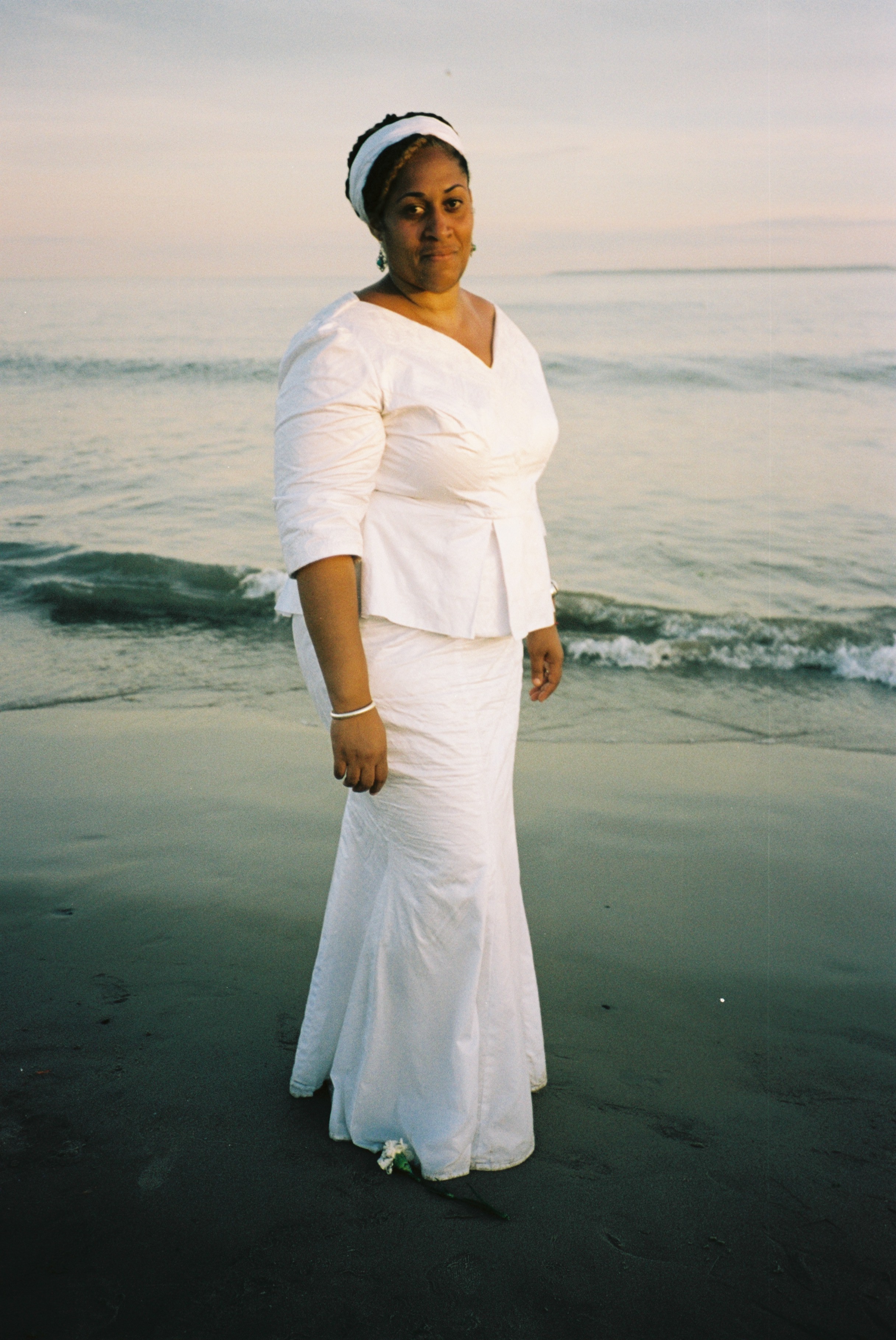donna in spiaggia con vestito bianco