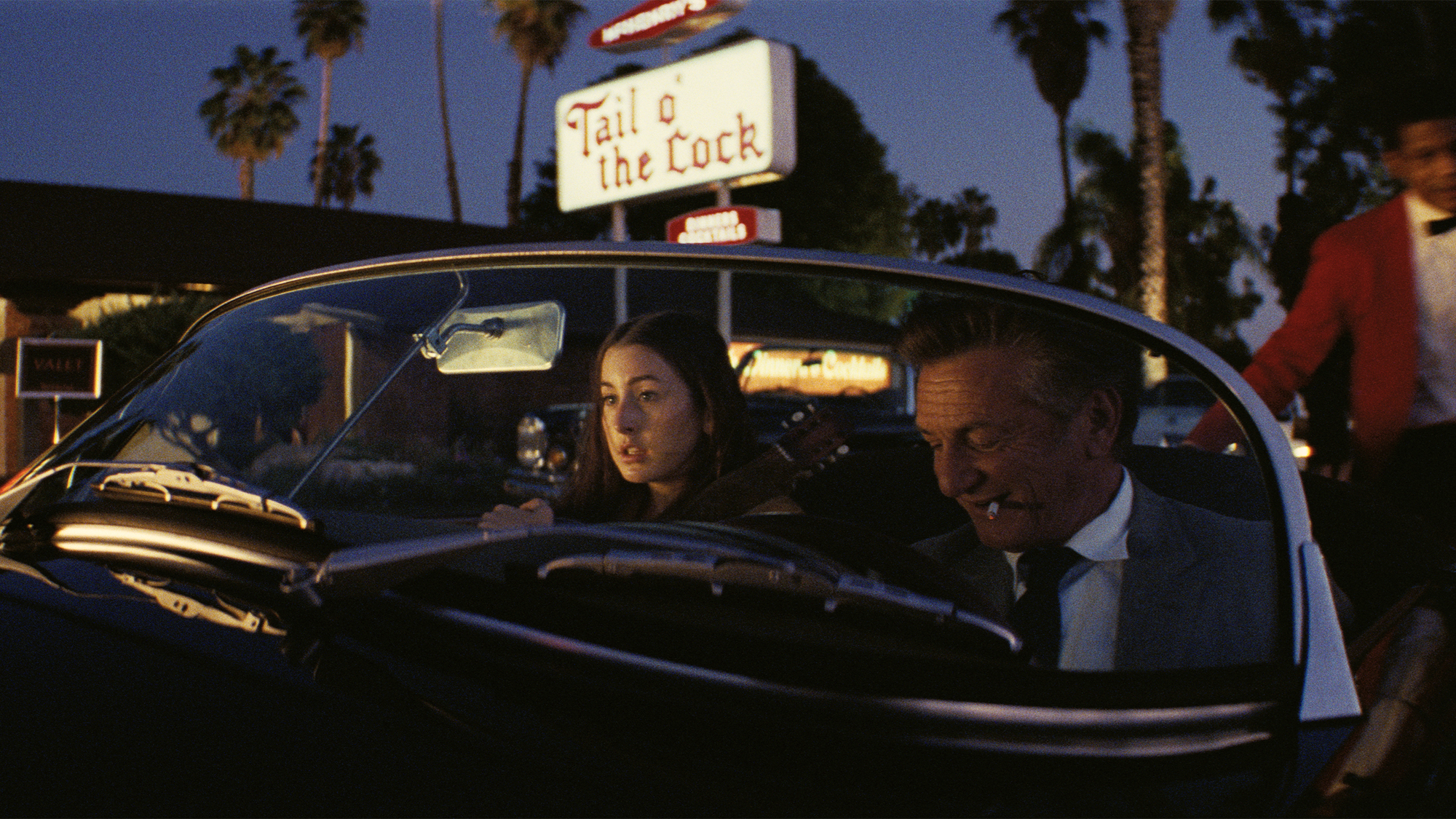alana sits in a car with drunken movie star jack holden (played by sean penn)