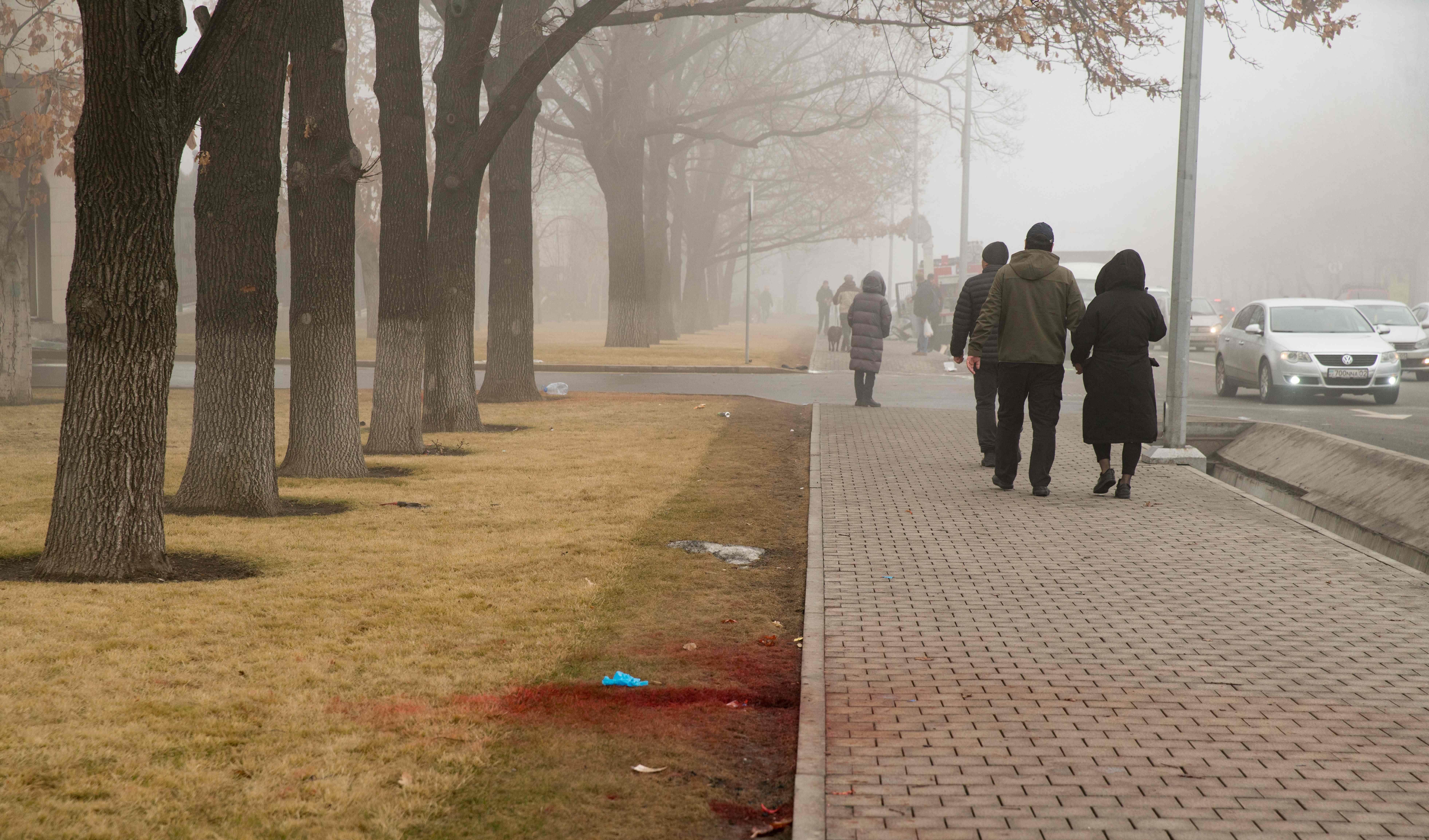 People walk past blood in Almaty on Thursday following violent protests. Photo: ALEXANDER BOGDANOV/AFP via Getty Images