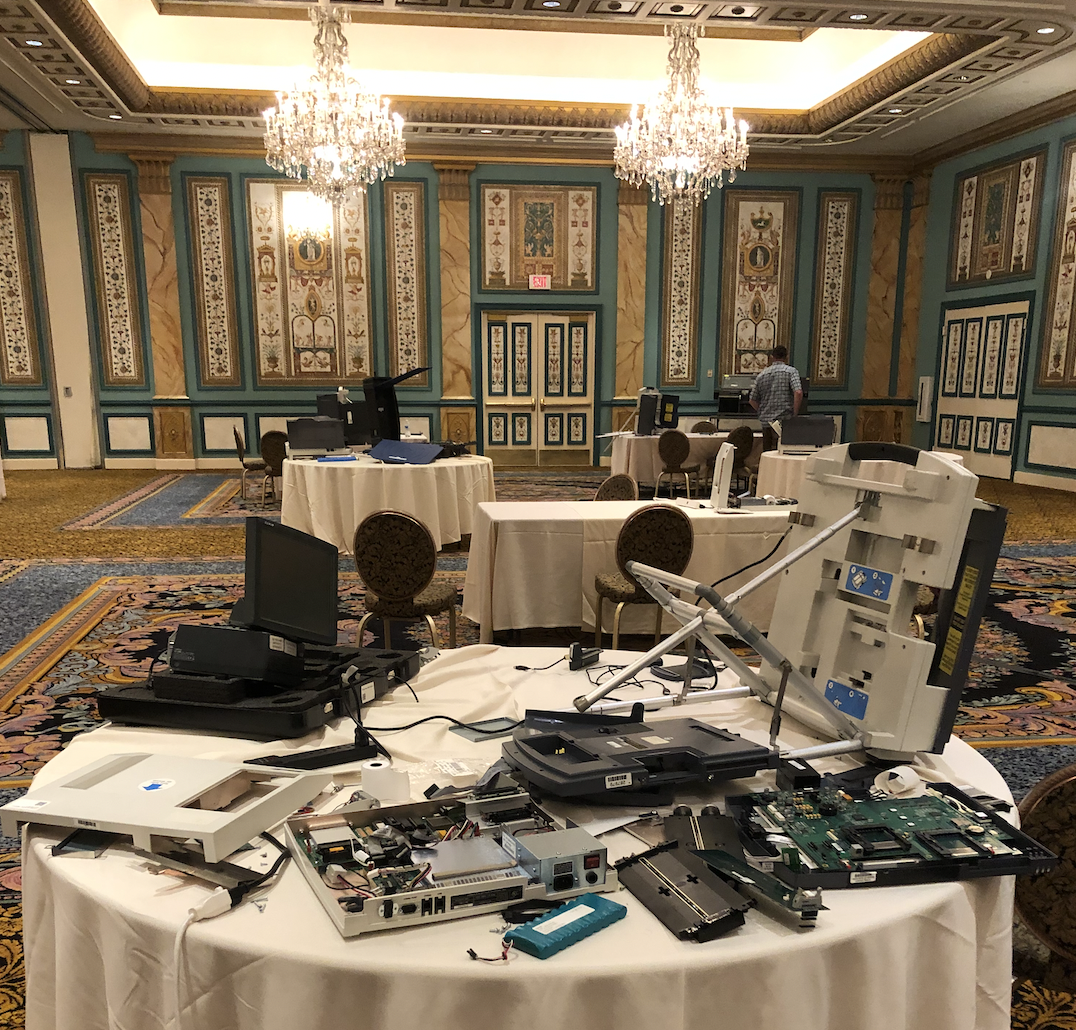 Hacked and dismantled voting machines are left behind at the conference. (Spenser Mestel for VICE News)