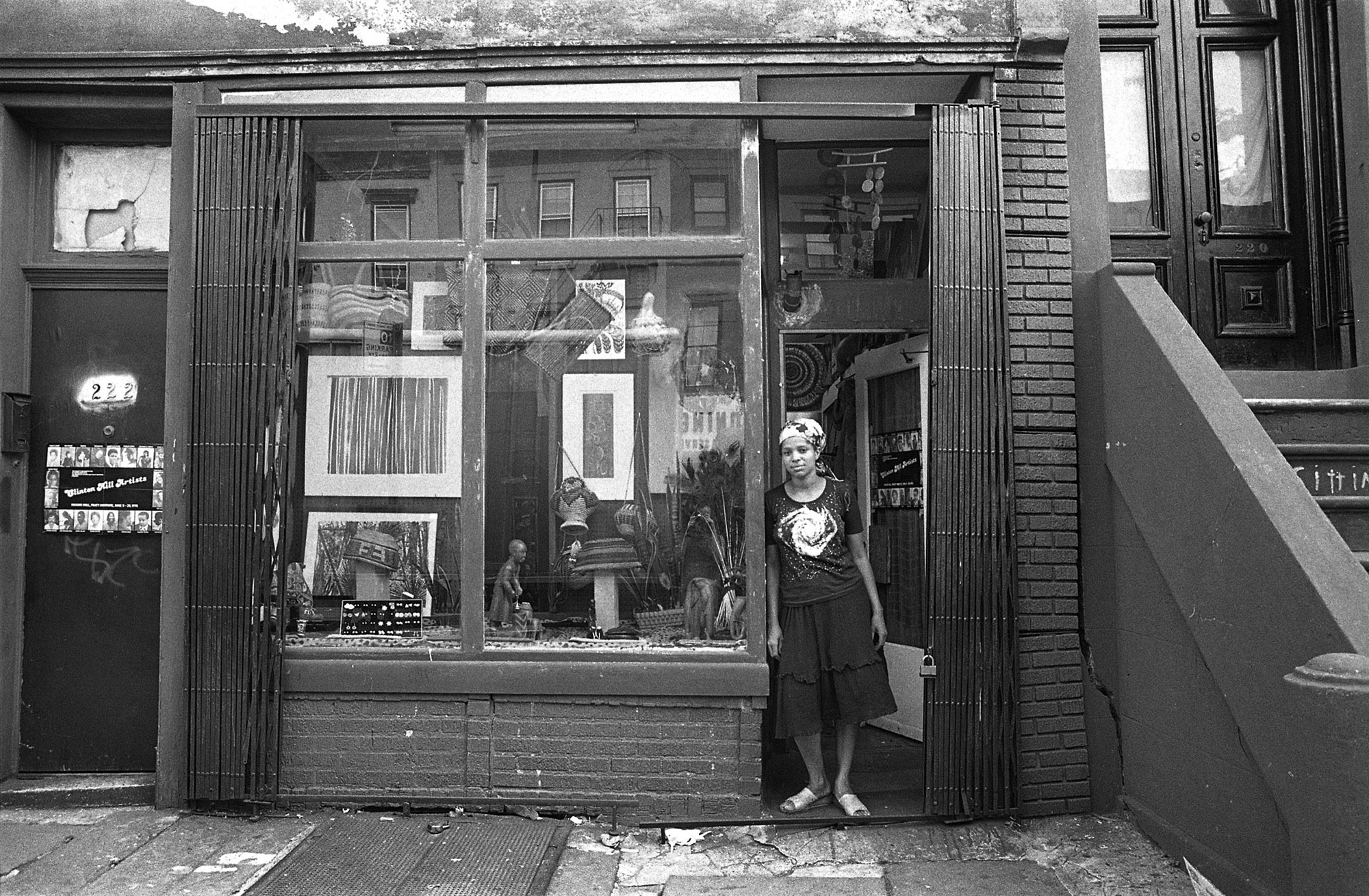 a person stands in front of the open door of a store or gallery