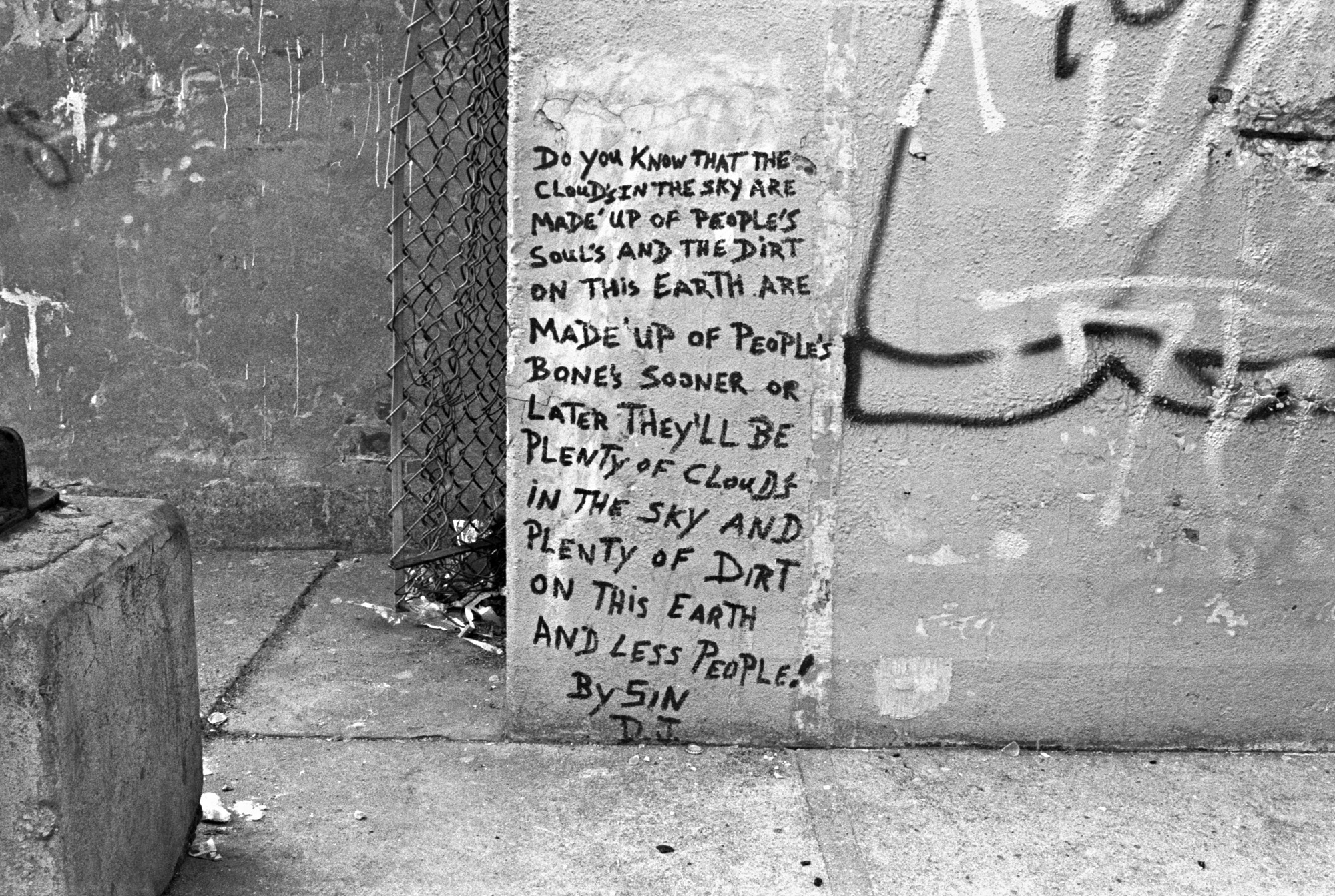 a black and white photograph of some graffiti written on a dirty wall