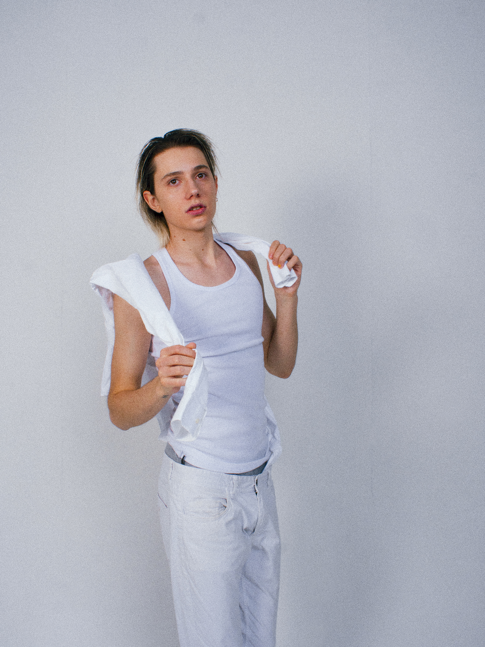fotografia cantante gianmaria con pantaloni bianchi e camicia bianca sulle spalle