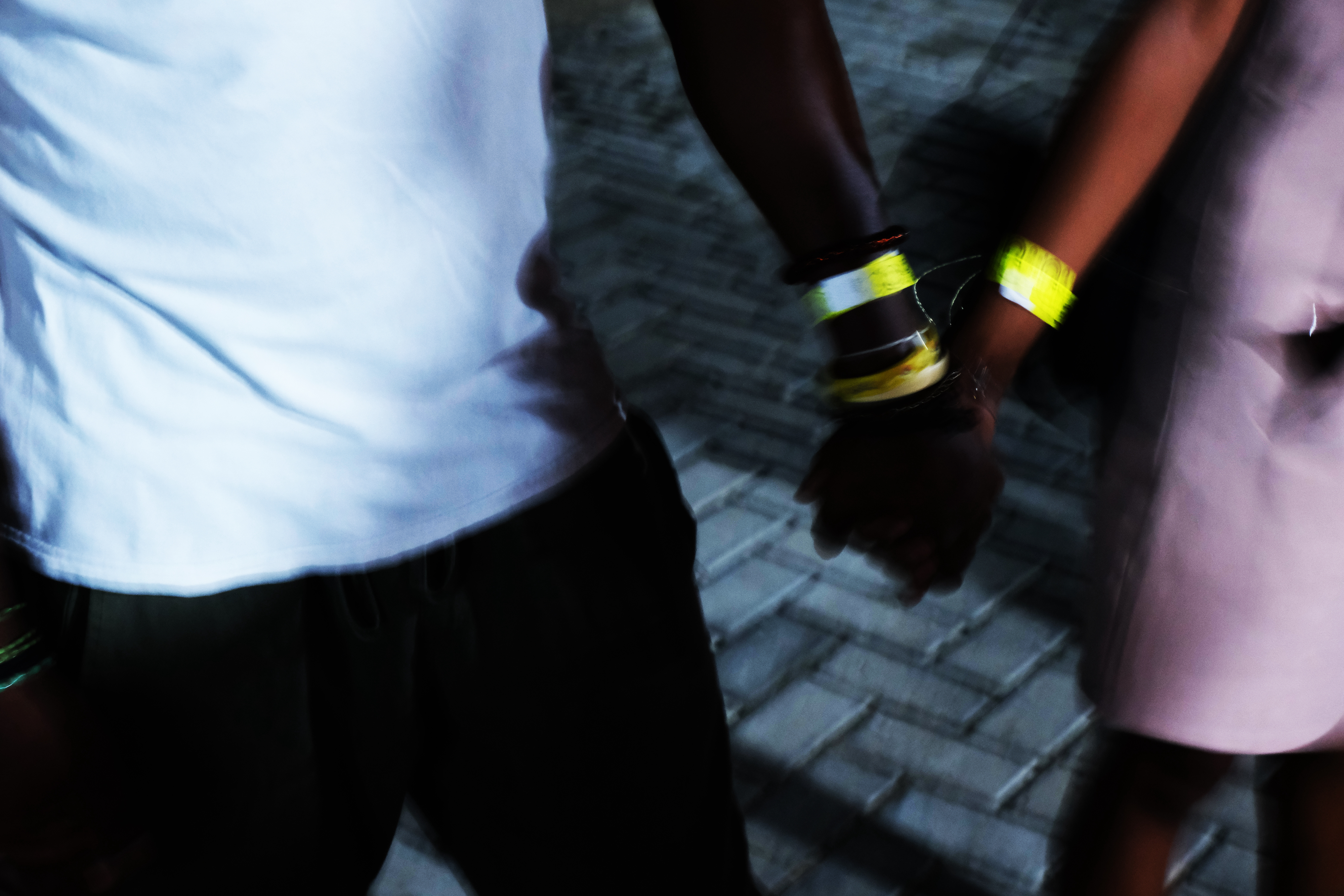 two people hold hands wearing nightclub wristbands in lagos