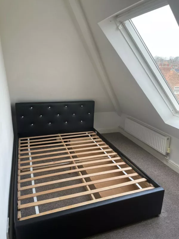 An empty bedframe in the bedroom of small one-bedroom flat in Sherwood, Nottinghamshire