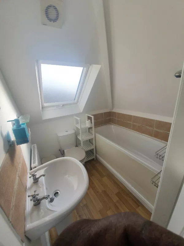 A small bathroom partially showing someone's body in small one-bedroom flat in Sherwood, Nottinghamshire