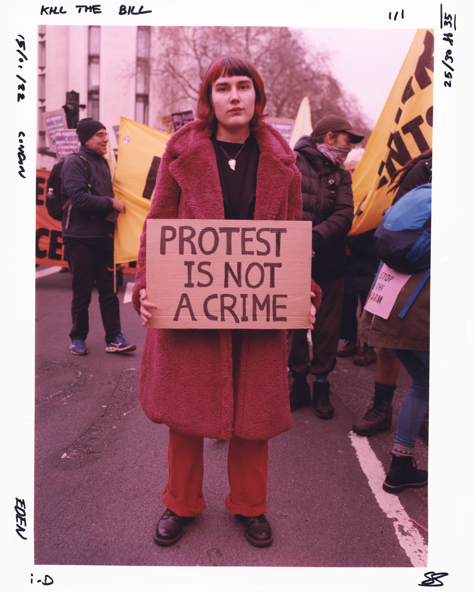 Protester in all red holding a sign saying