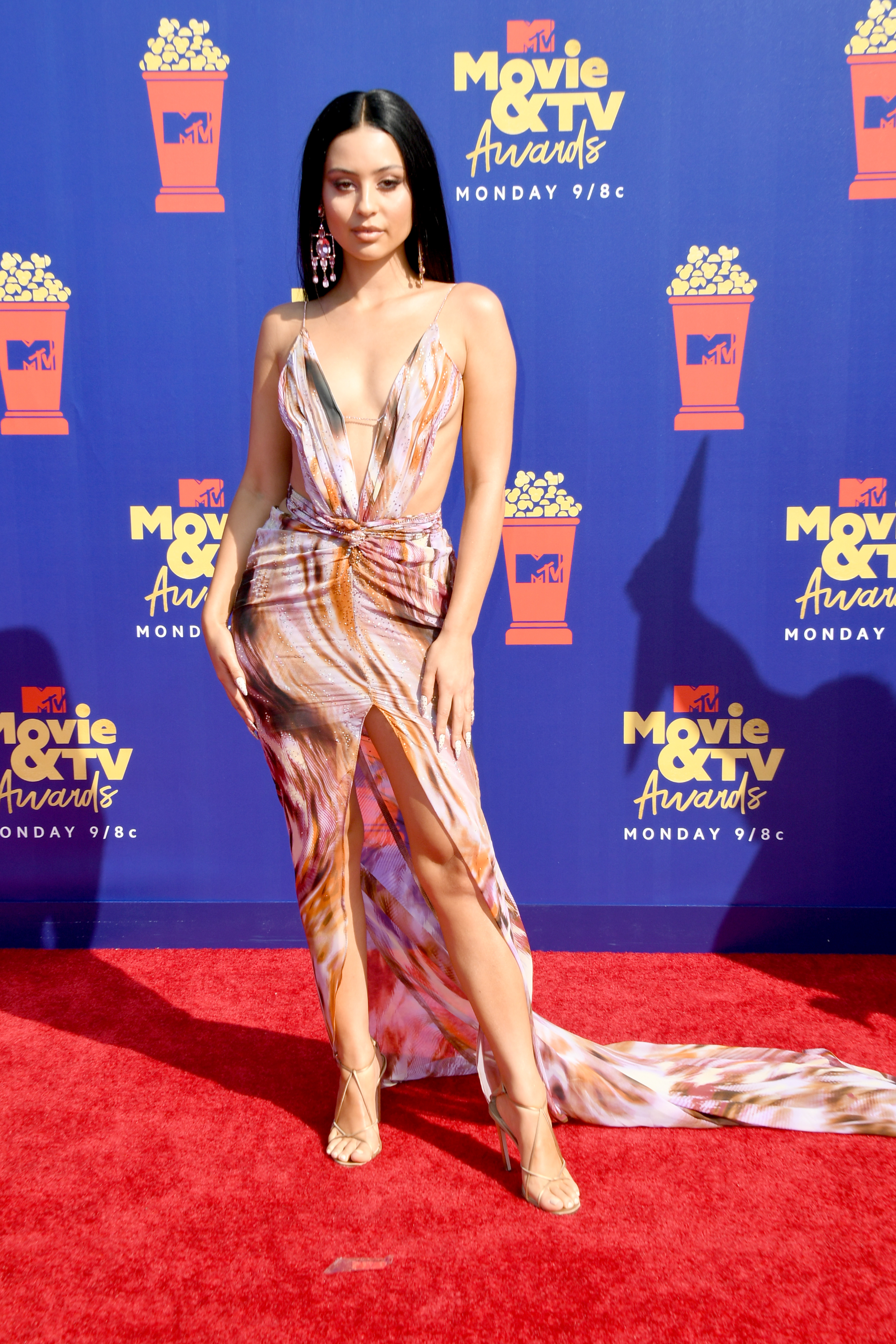 Alexa Demie at the MTV Movie and TV Awards in 2019 wearing a pinks and orange print cut-out dress. 