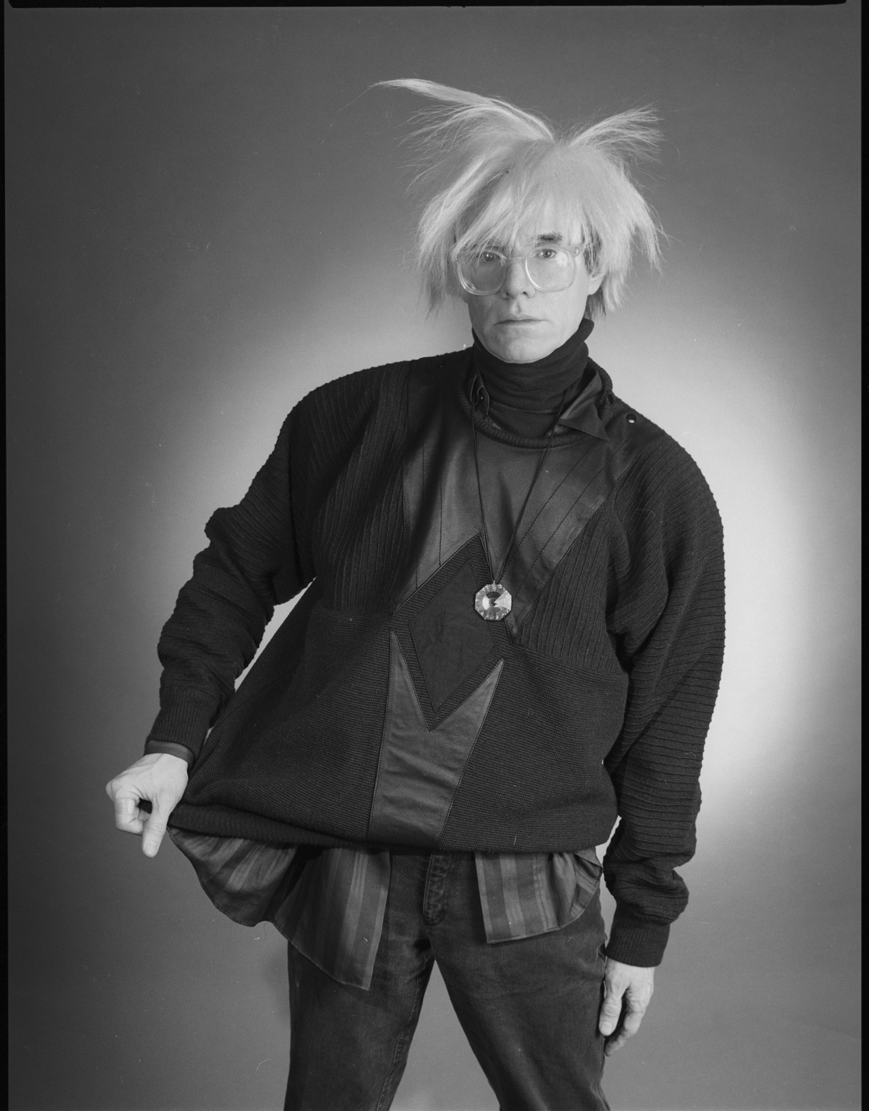 andy warhol clutching a stephen sprouse outfit in a black and white image by christopher makos