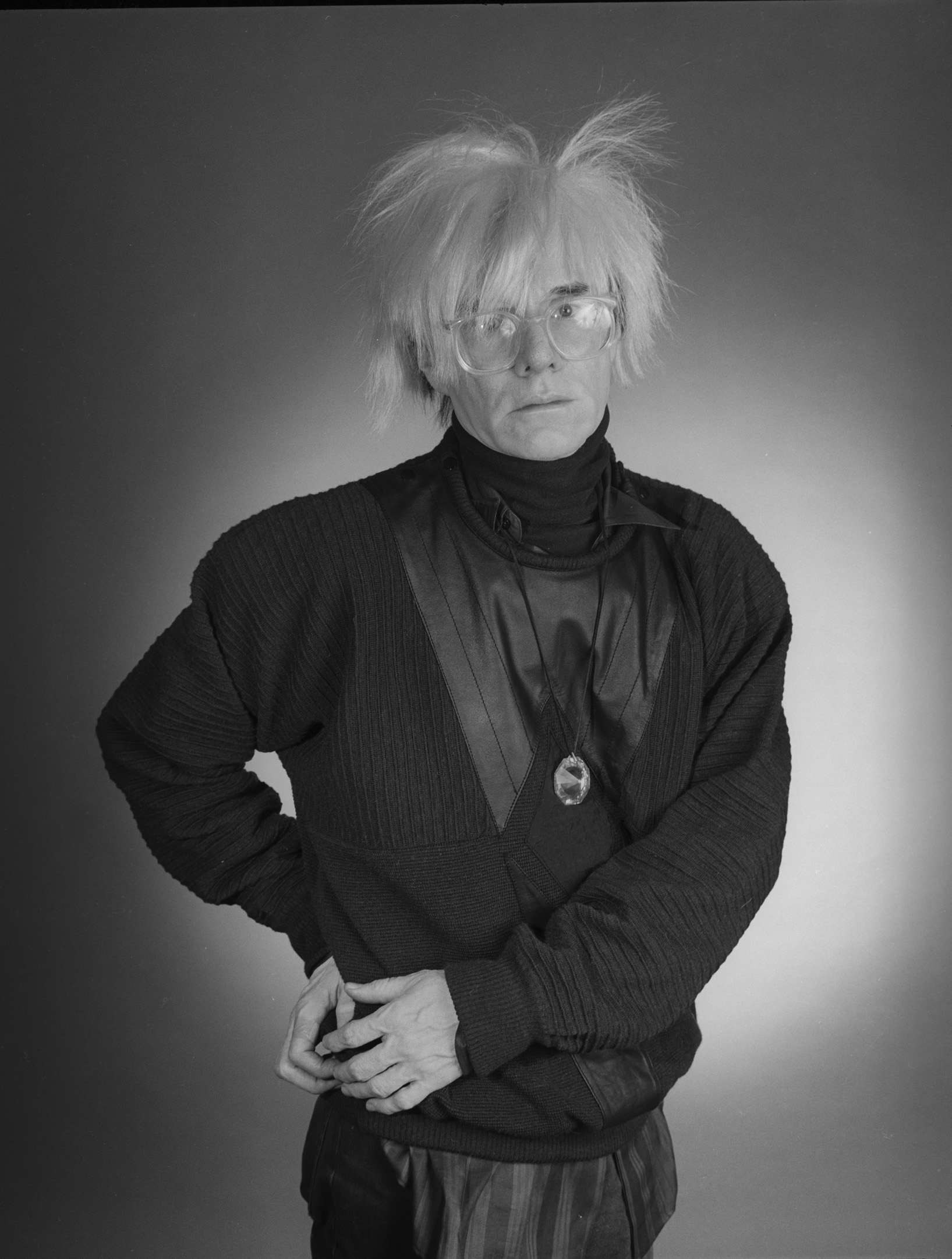 andy warhol with his hands on his hips in a black and white image by christopher makos