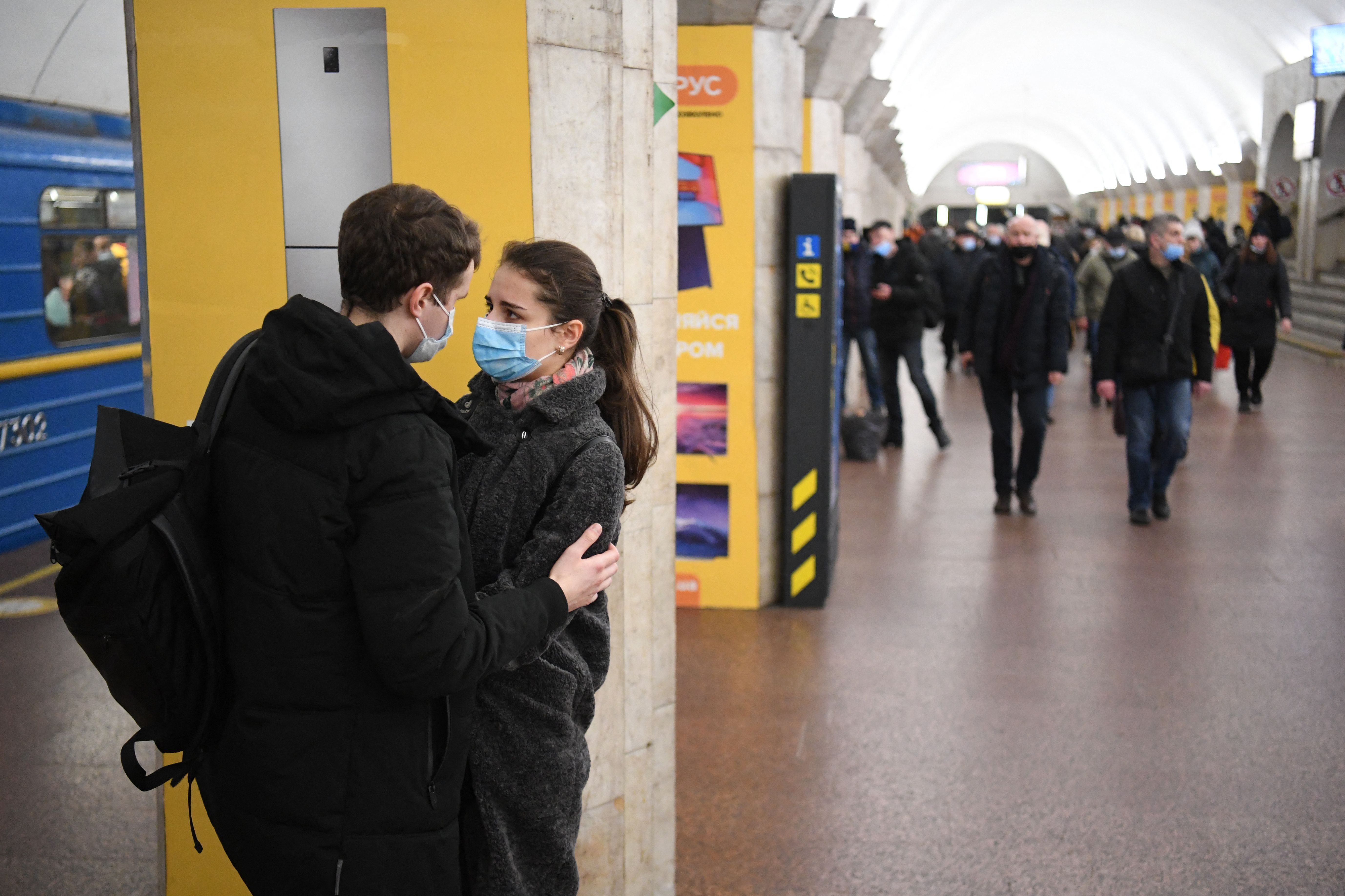 A couple speaks with each other at a metro station in Kyiv early on February 24, 2022