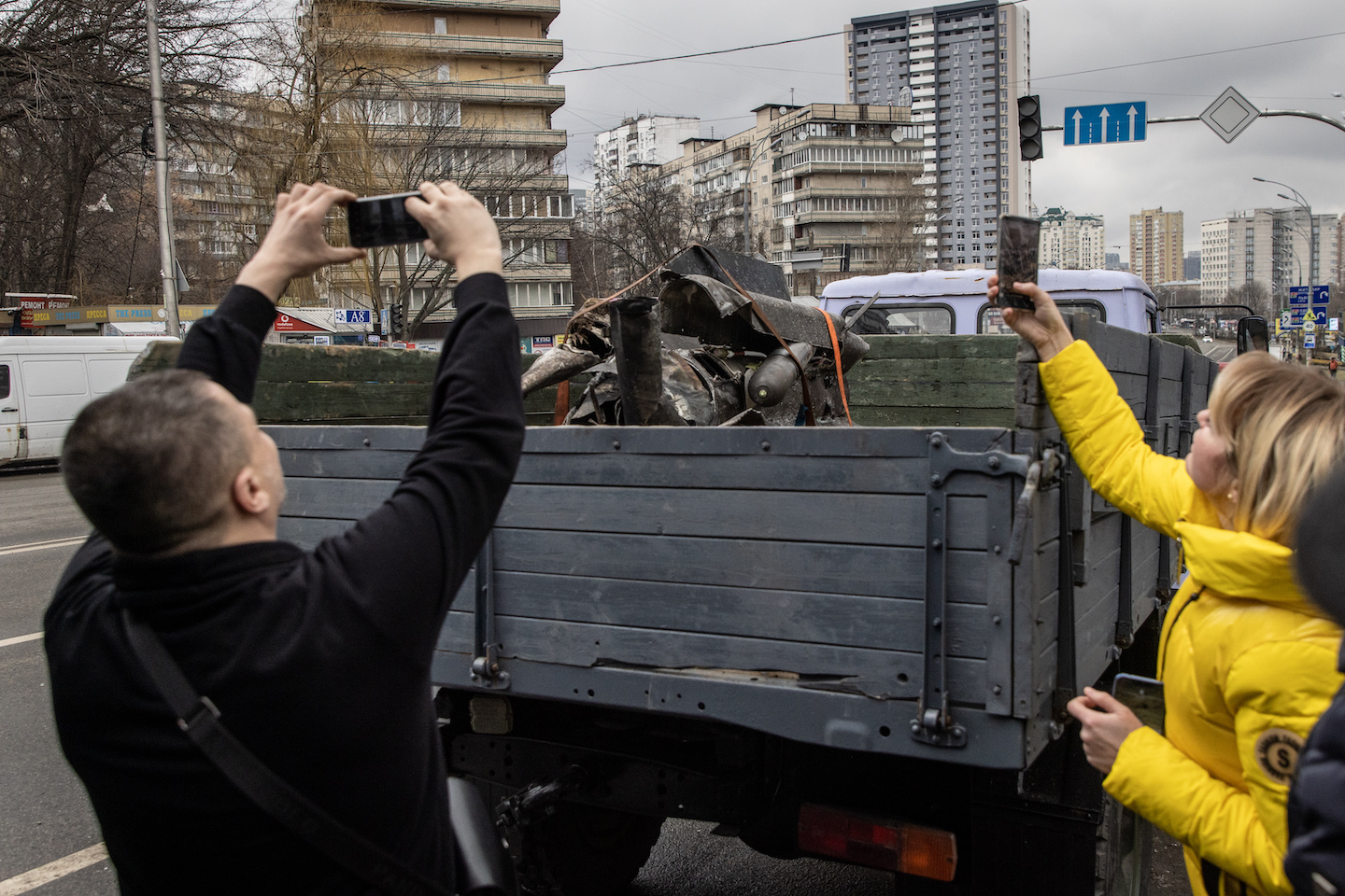 People take photos of a rocket as it is removed on February 24, 2022 in Kyiv, Ukraine.