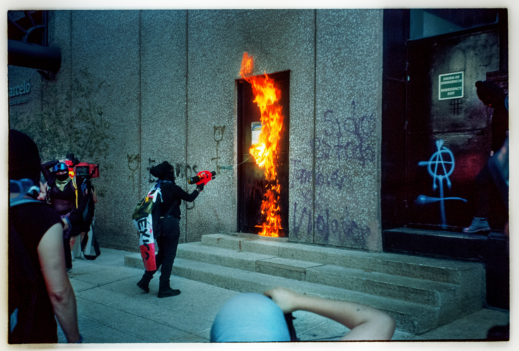 manifestante che mette a fuoco una porta 8 marzo foto ludovica anzaldi
