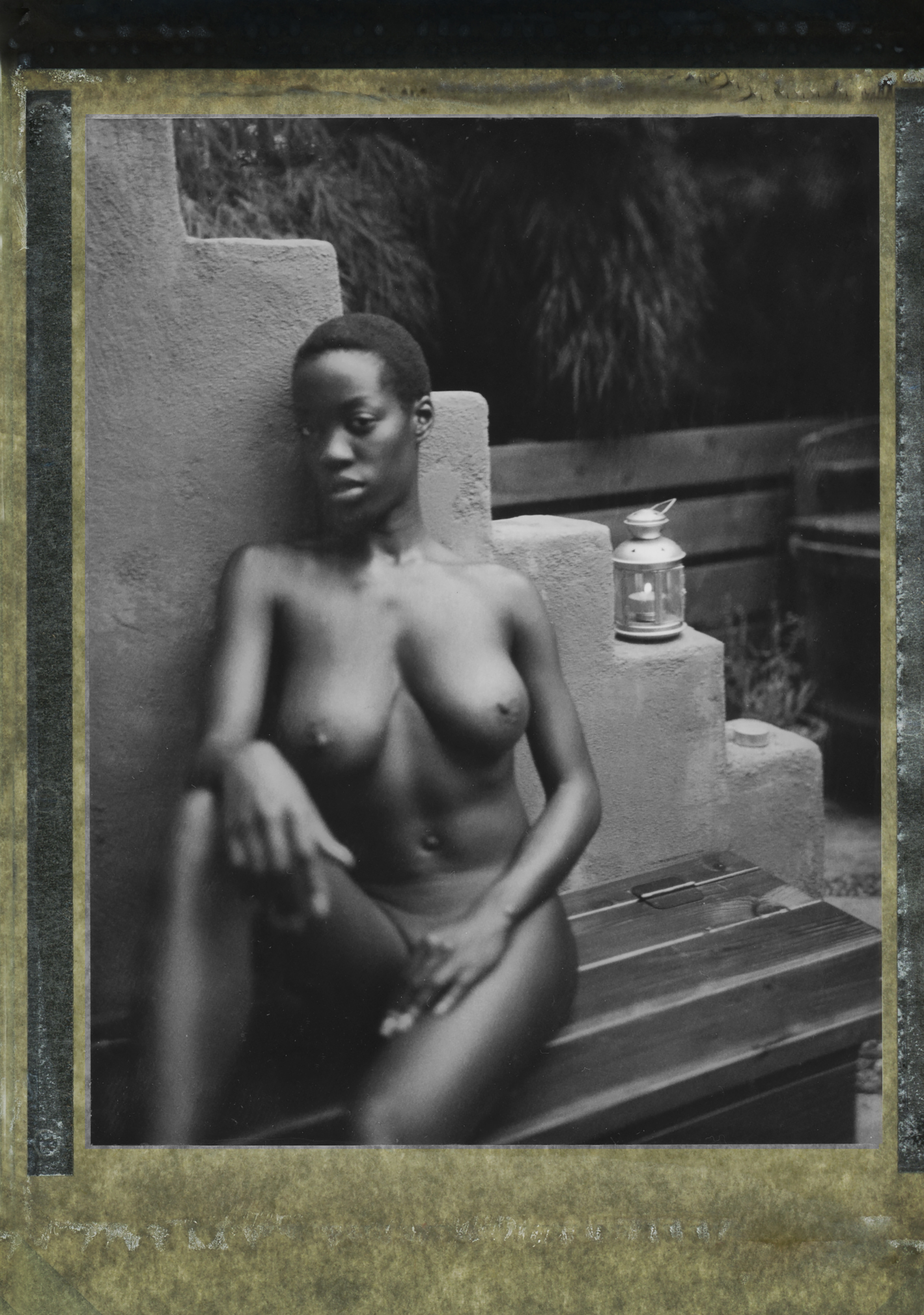 a naked woman sits on a bench outside