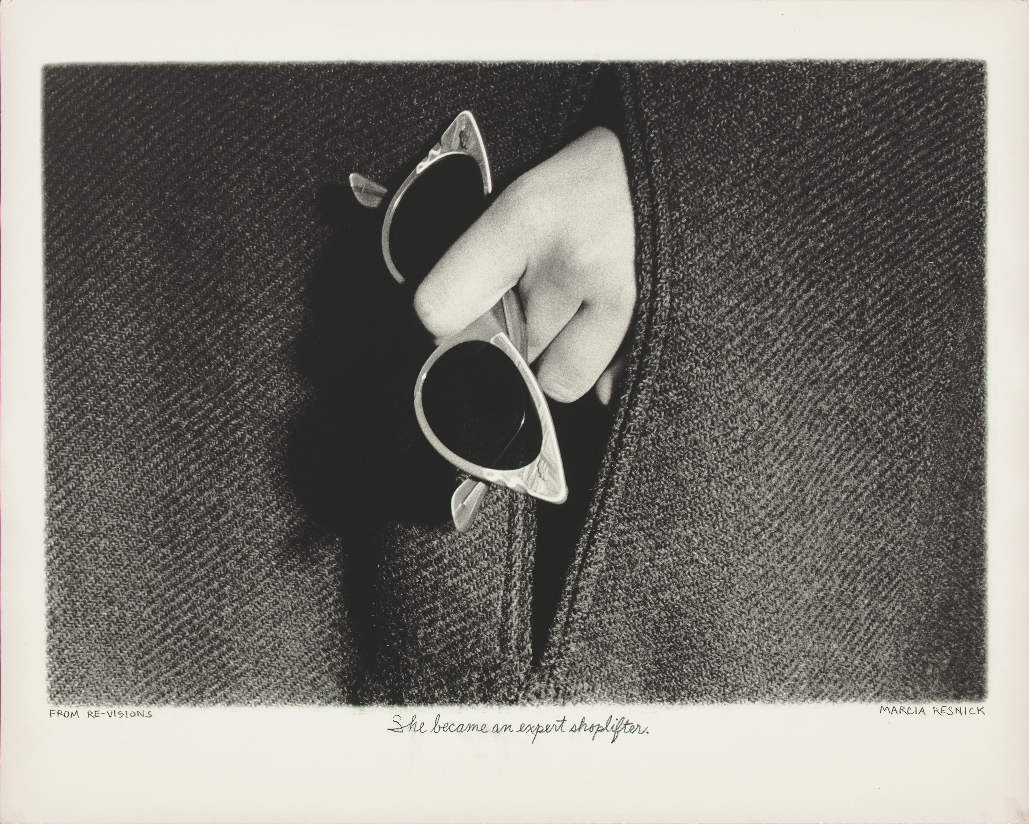 Photograph of a hand holding a pair of sunglasses by Marcia Resnick