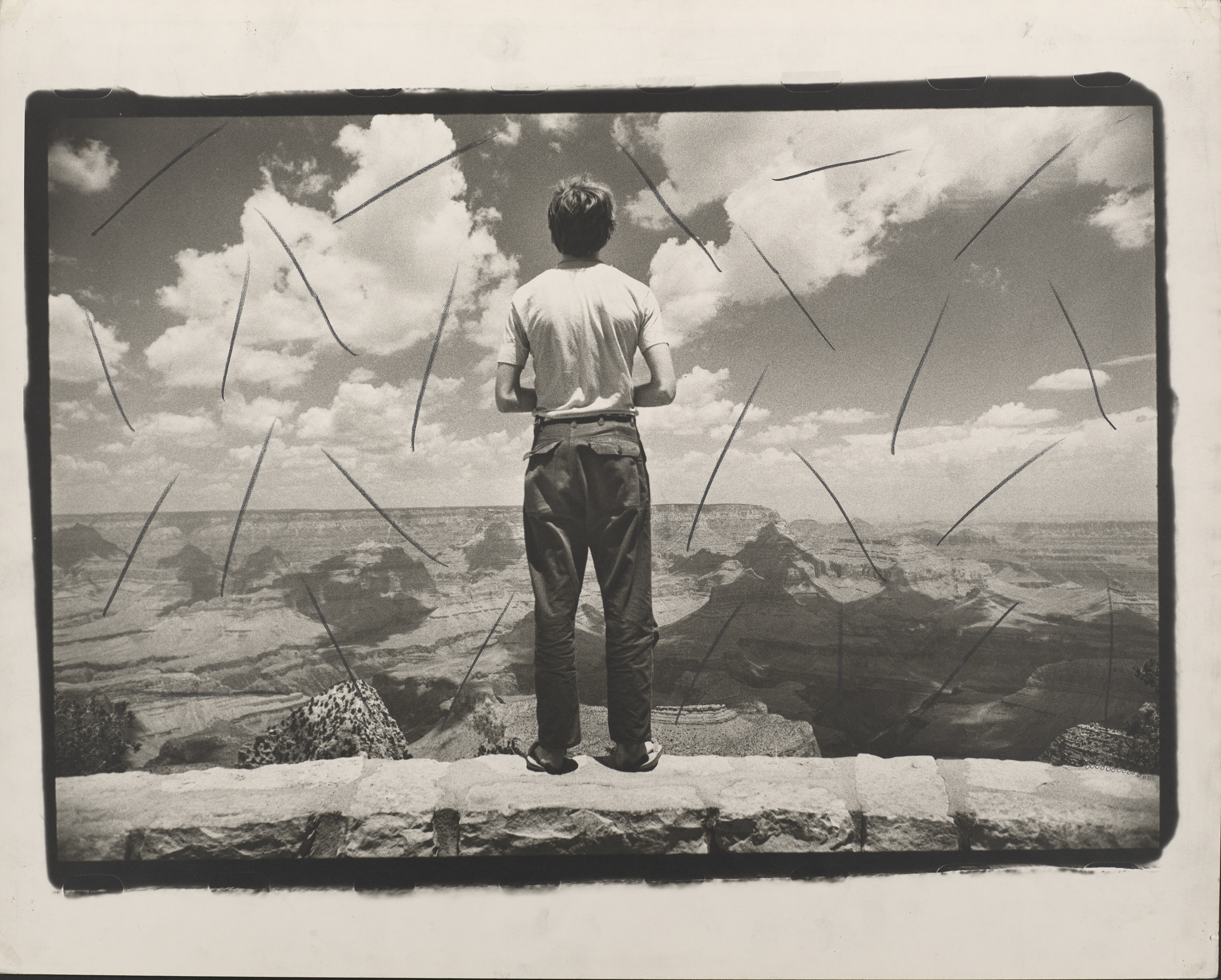 Photograph of a man staring out over a desert valley by Marcia Resnick.