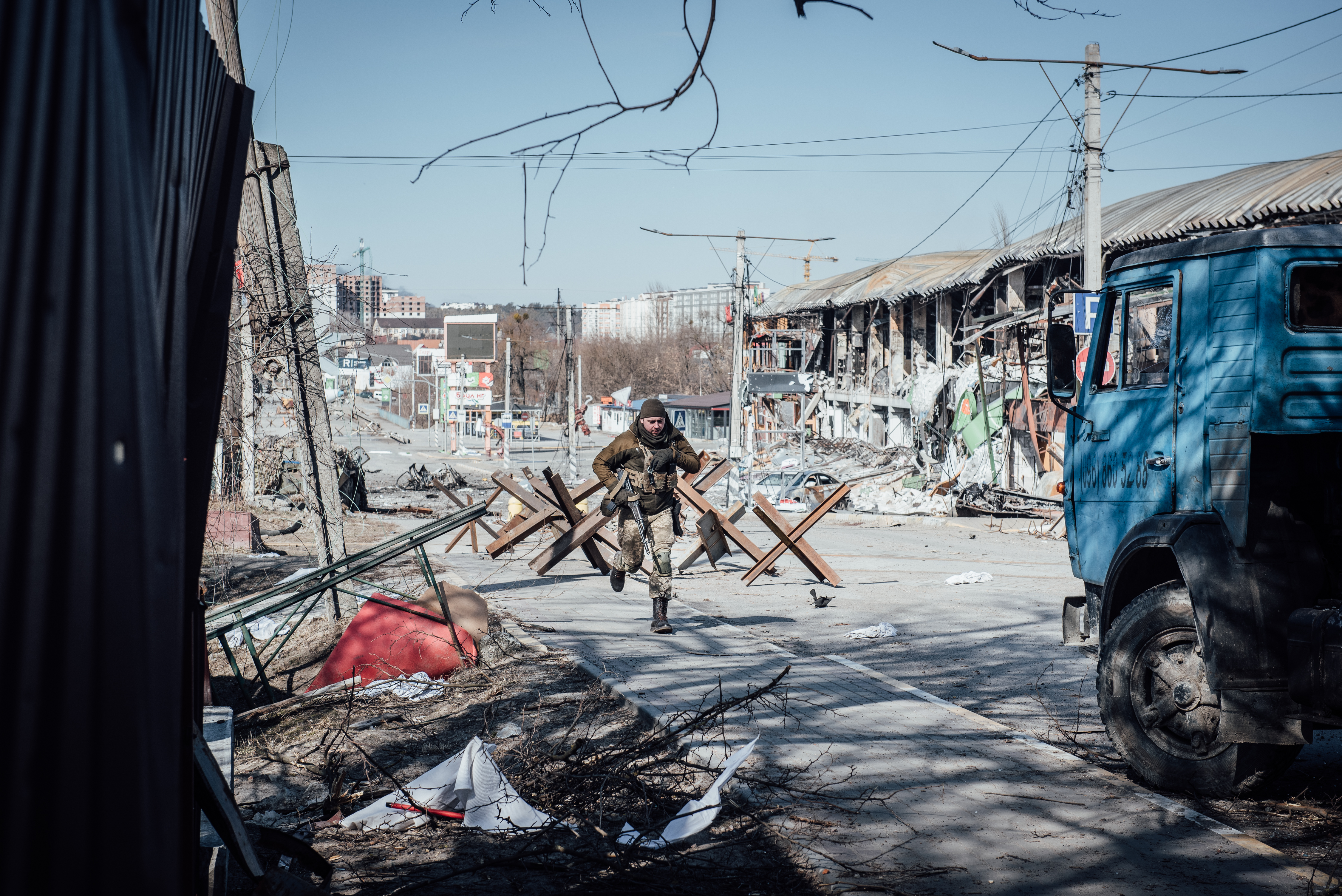 Tentara Ukraina berlari di garis depan yang berada di perbatasan kota Irpin dan Bucha, yang diduduki Rusia selama sepekan. Foto diambil pada 11 Maret 2022.