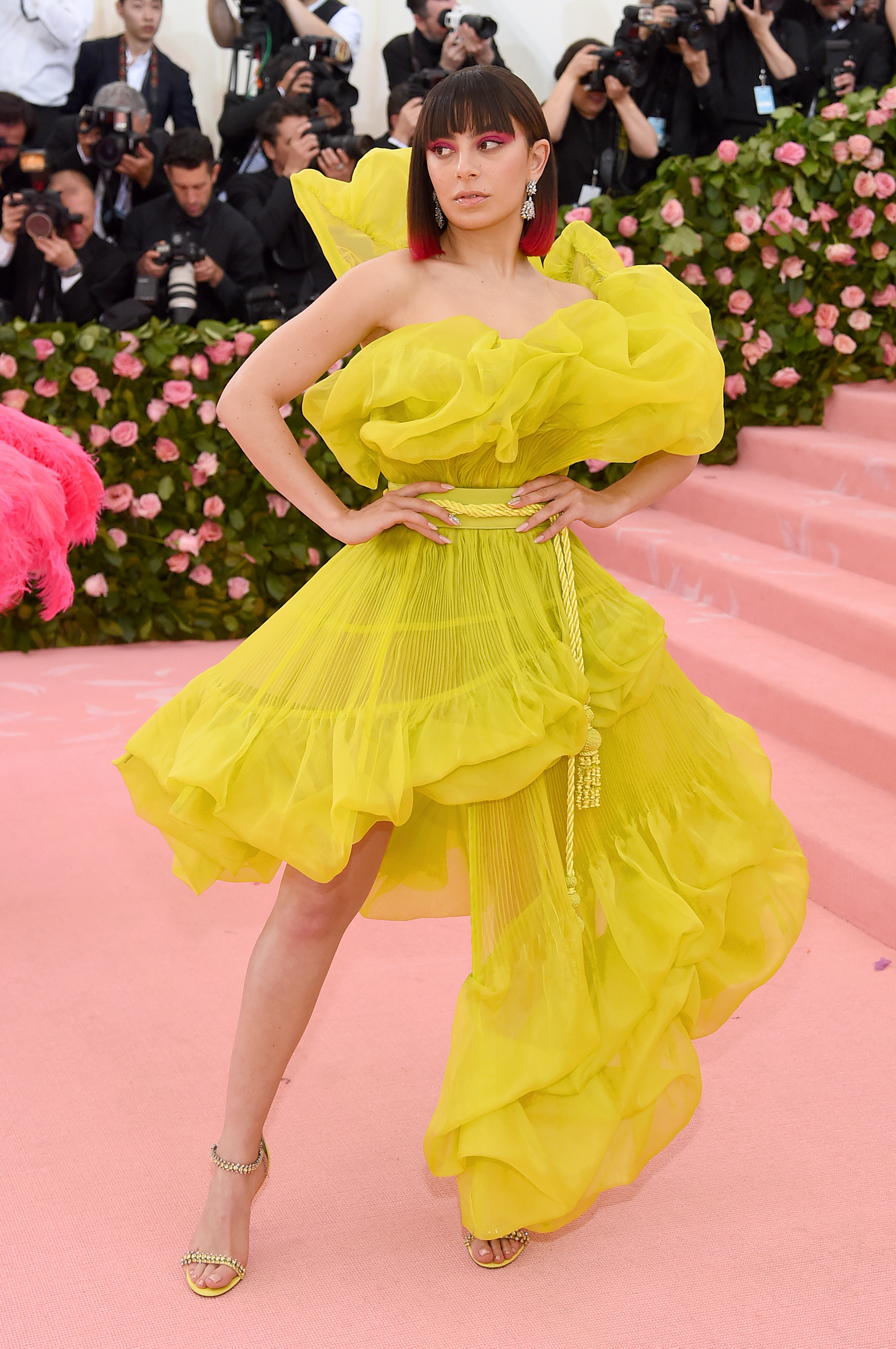 charli xcx posing at the met gala 2018 in a bright yellow dress and bob
