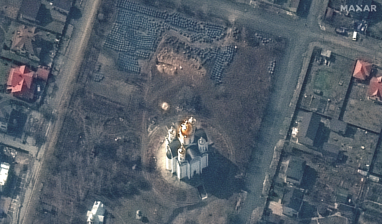 Tangkapan layar gambar satelit yang menunjukkan kuburan massal dekat gereja di Ukraina