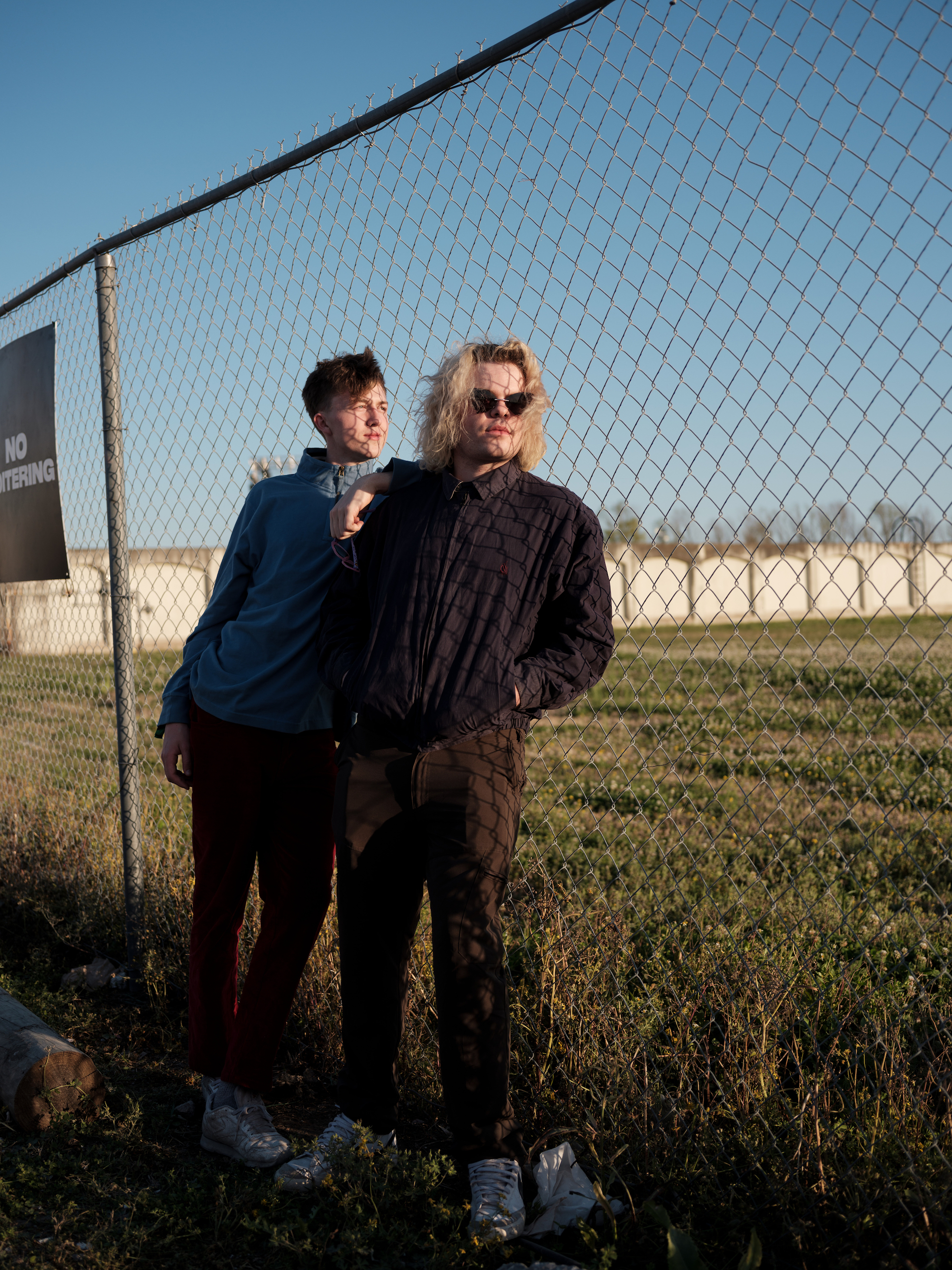 two people posing against a chainlink fence at buku music + arts festival in new orleans