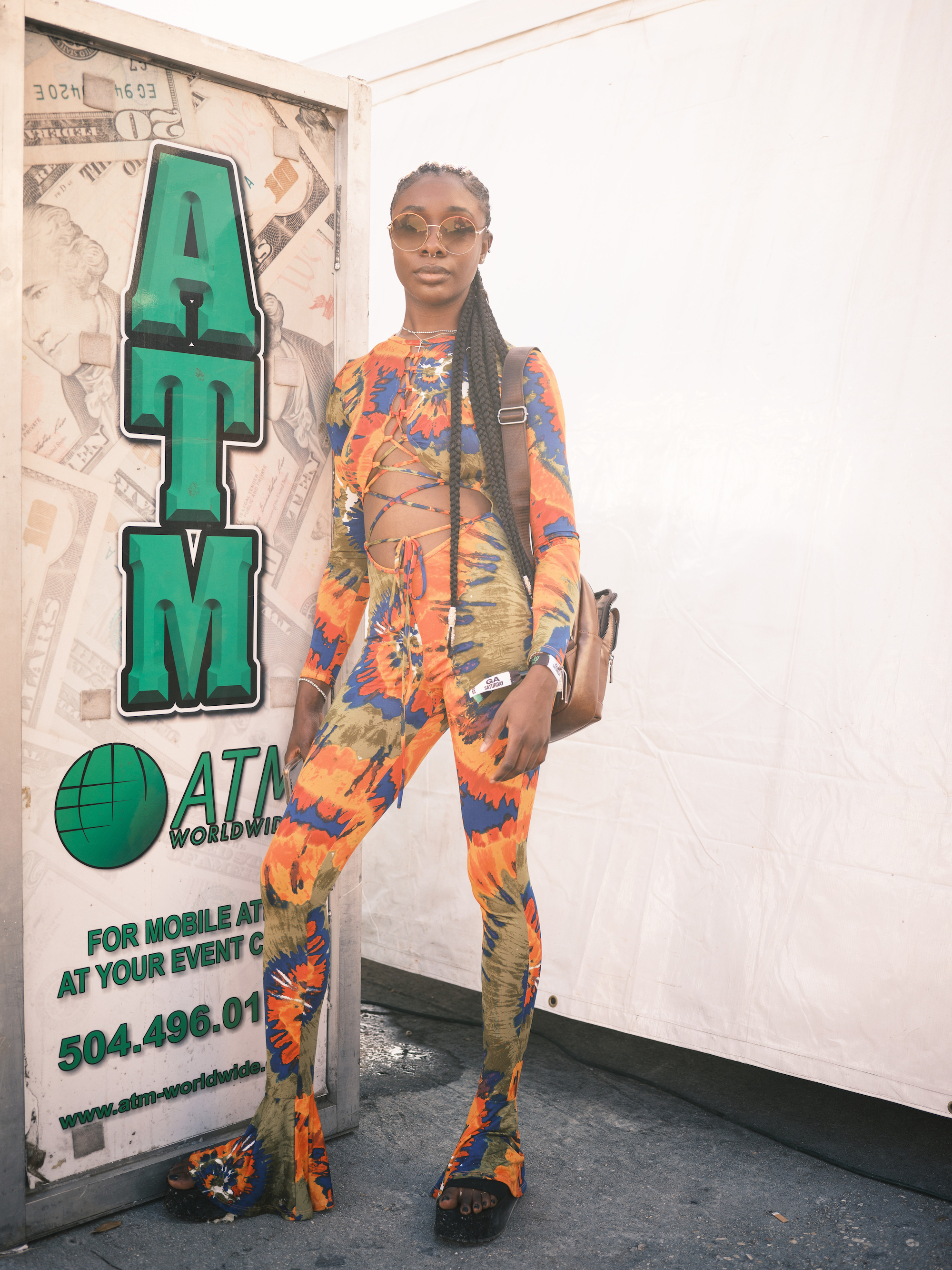 cherill posing in front of an atm at buku music + arts festival in new orleans
