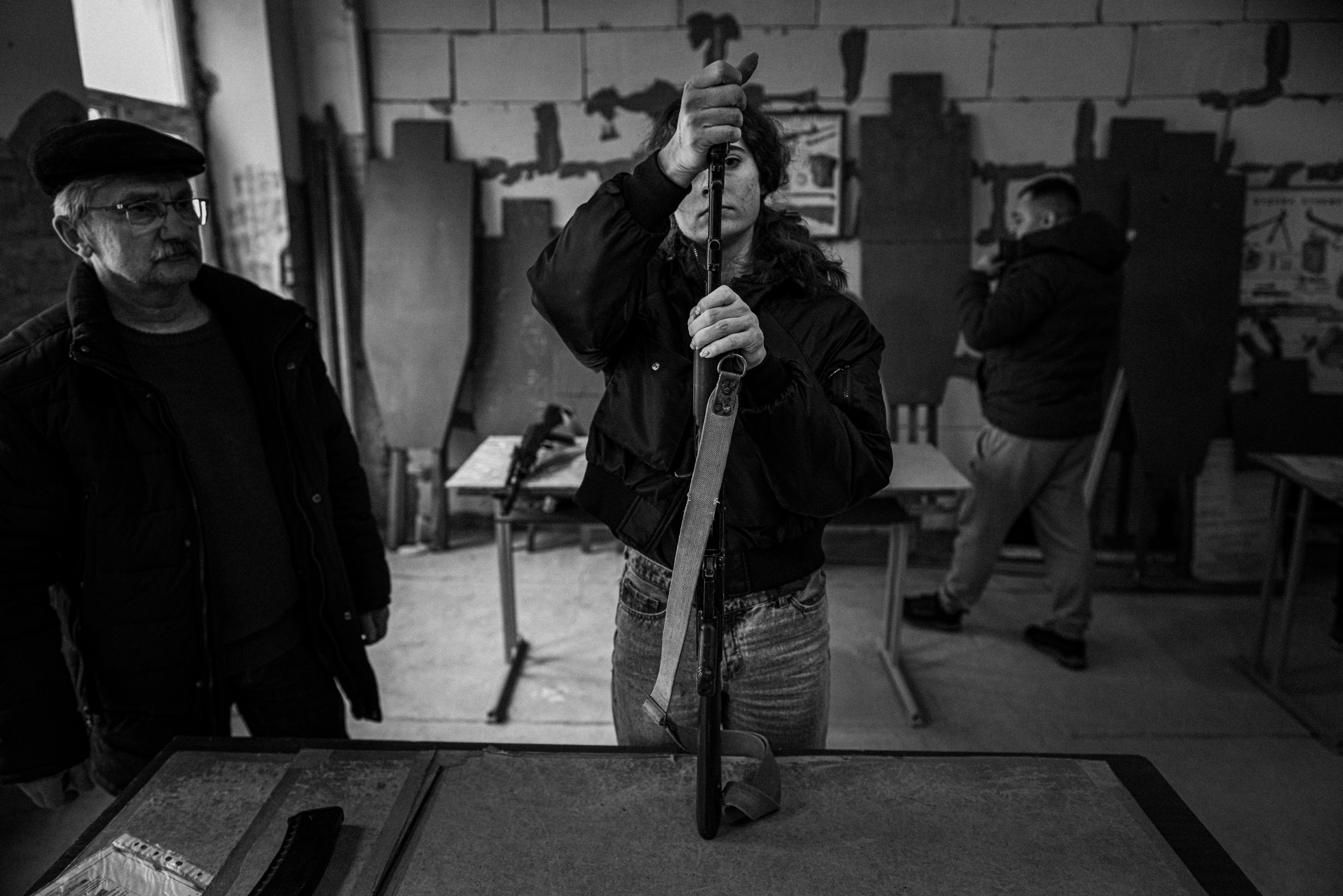 Perempuan belajar memasang senapan serbu di Odesa.