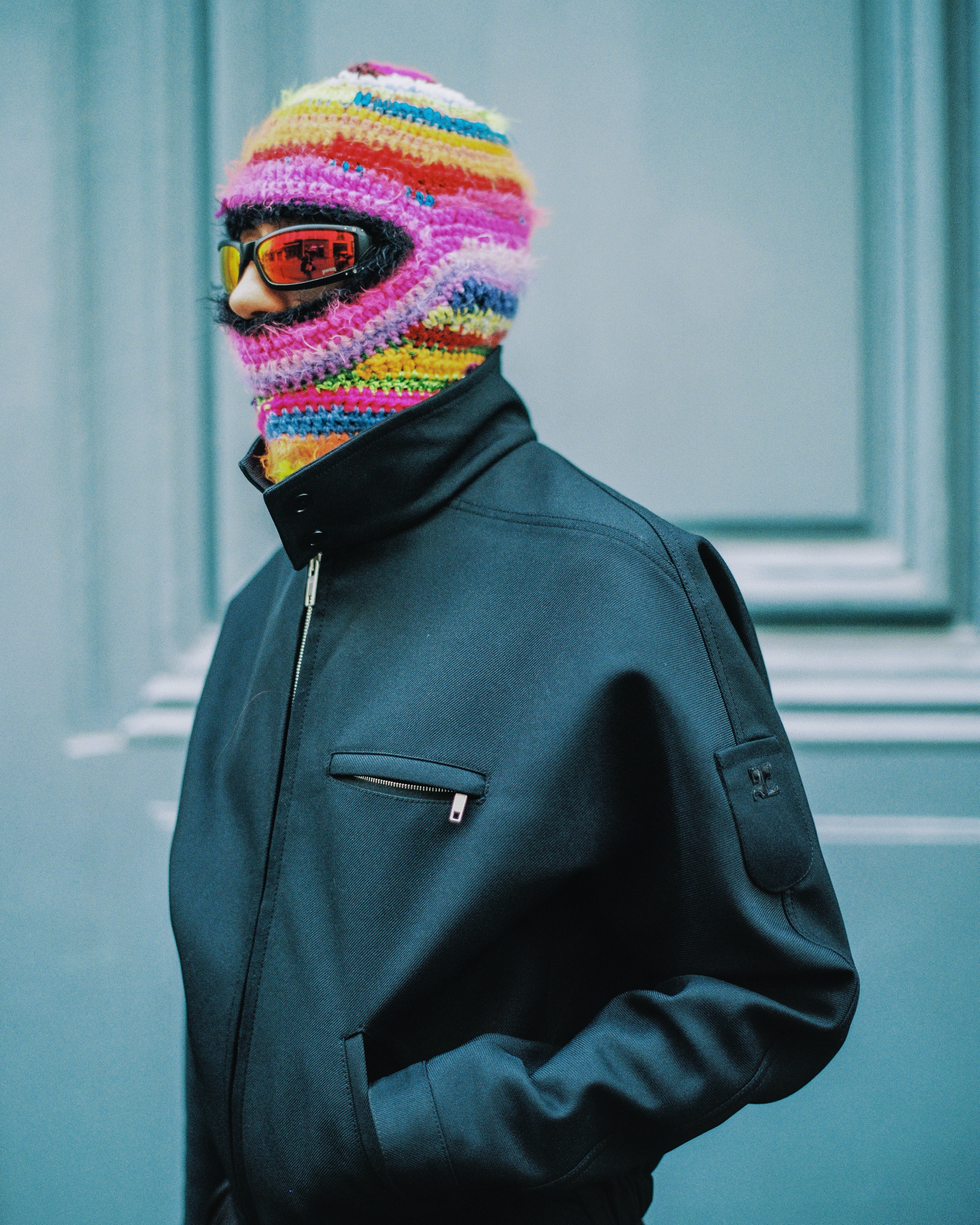 Chloe Caillet in a jacket and rainbow balaclava 