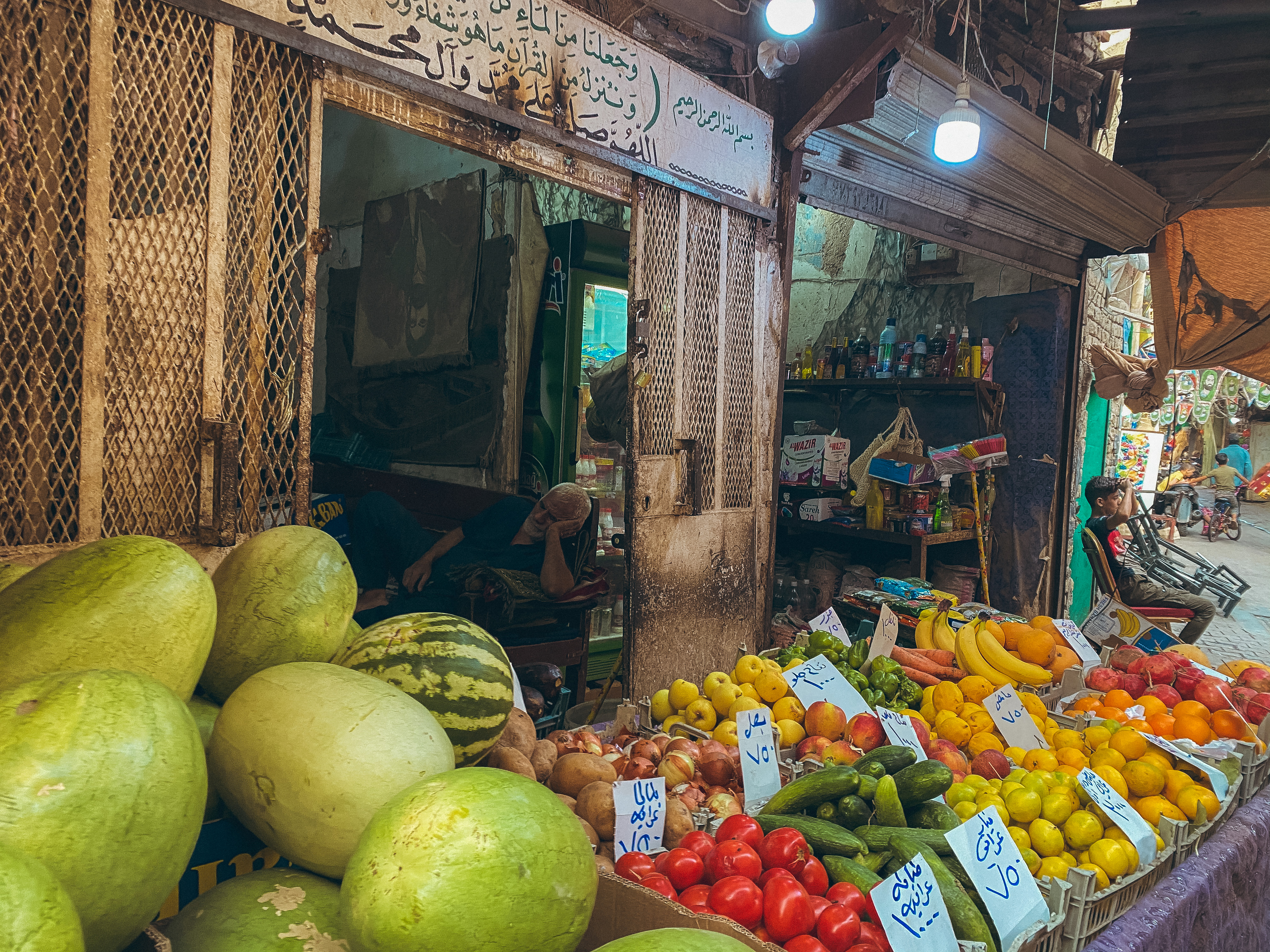 Pedagang buah tidur di dalam toko. Pasar Sadriya, Baghdad. Juni 2019.