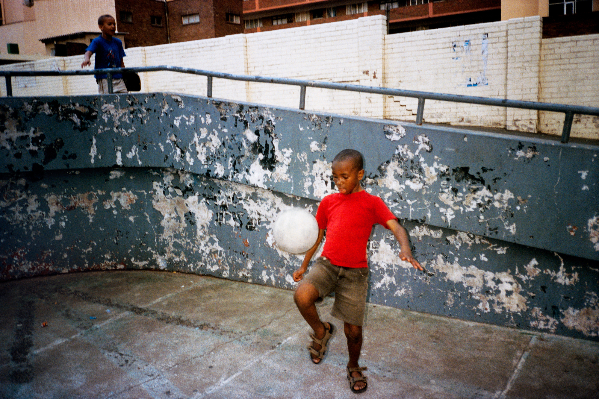 a boy playing soccer in new york city by jason dill