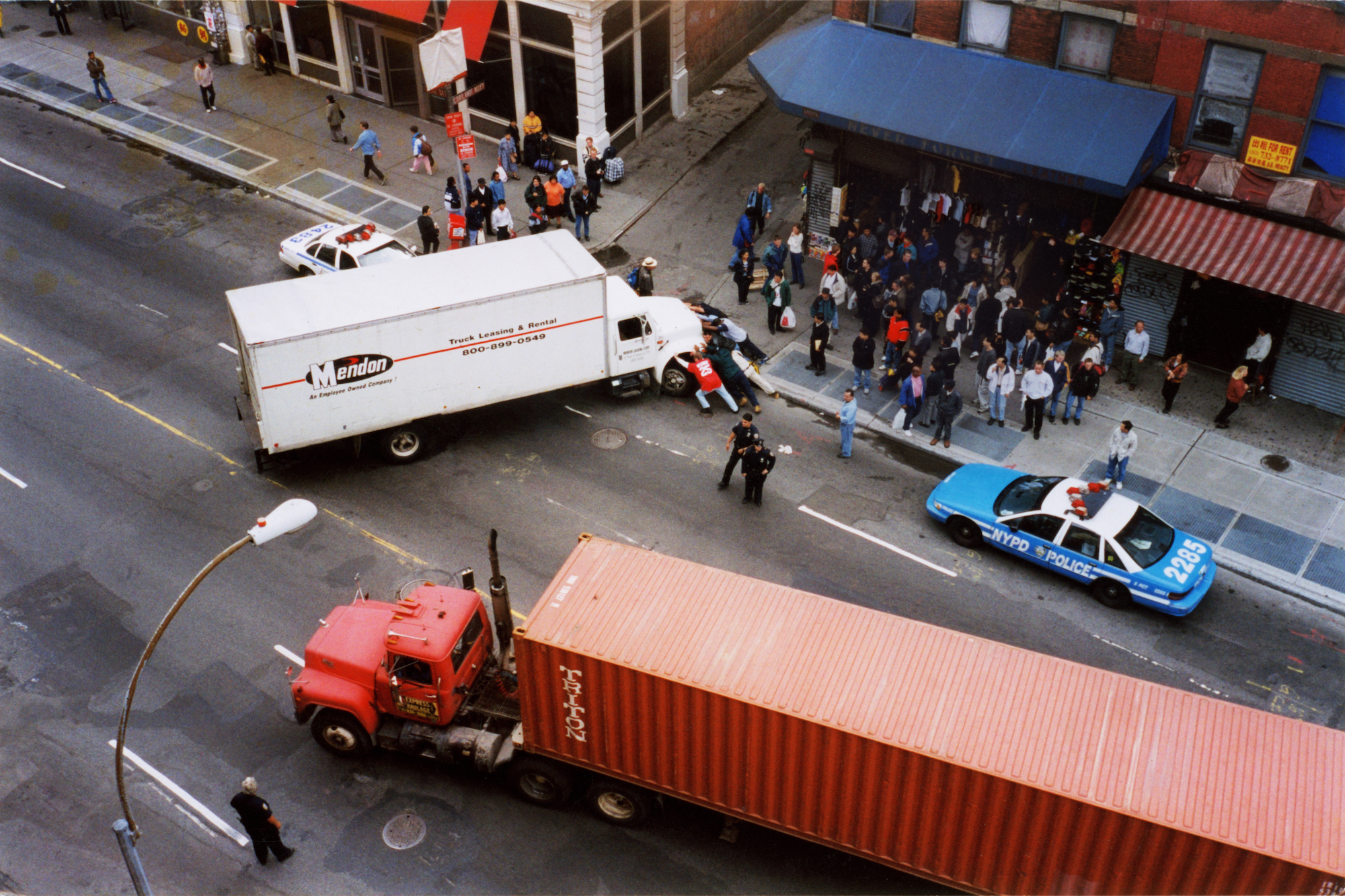 trucks and a crowd on a new york city street by jason dill