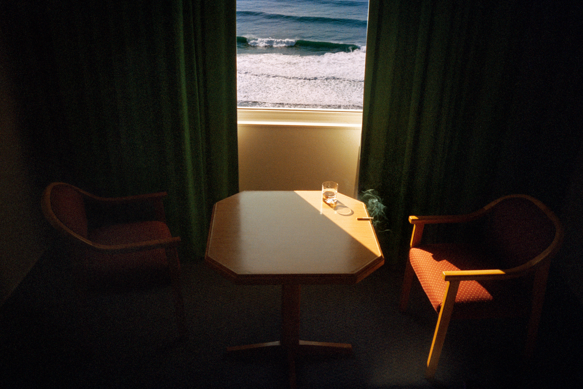 a table set in front of a hotel window with an ocean view by jason dill