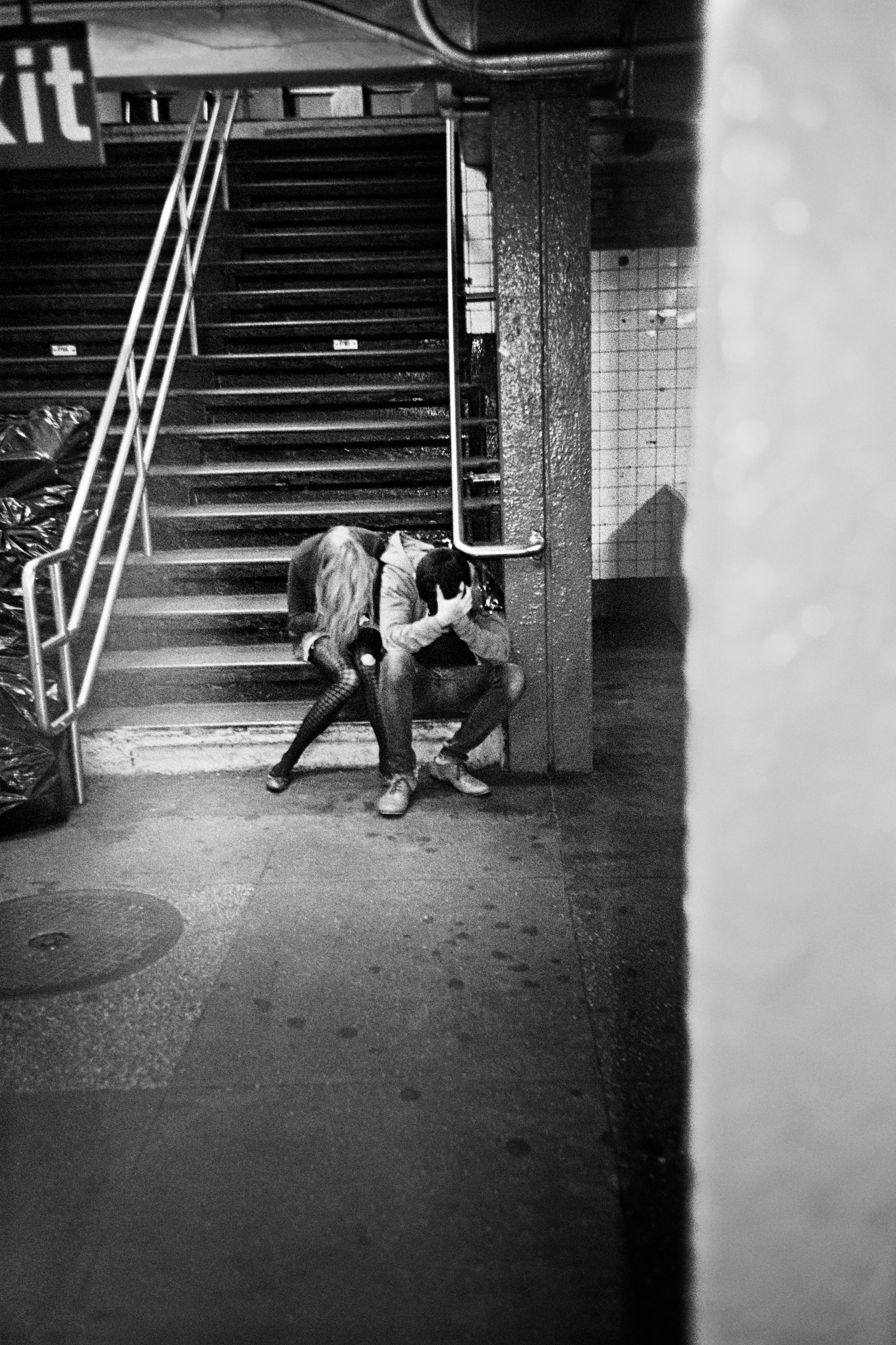 two teens bent over on the subway steps in new york city by jason dill