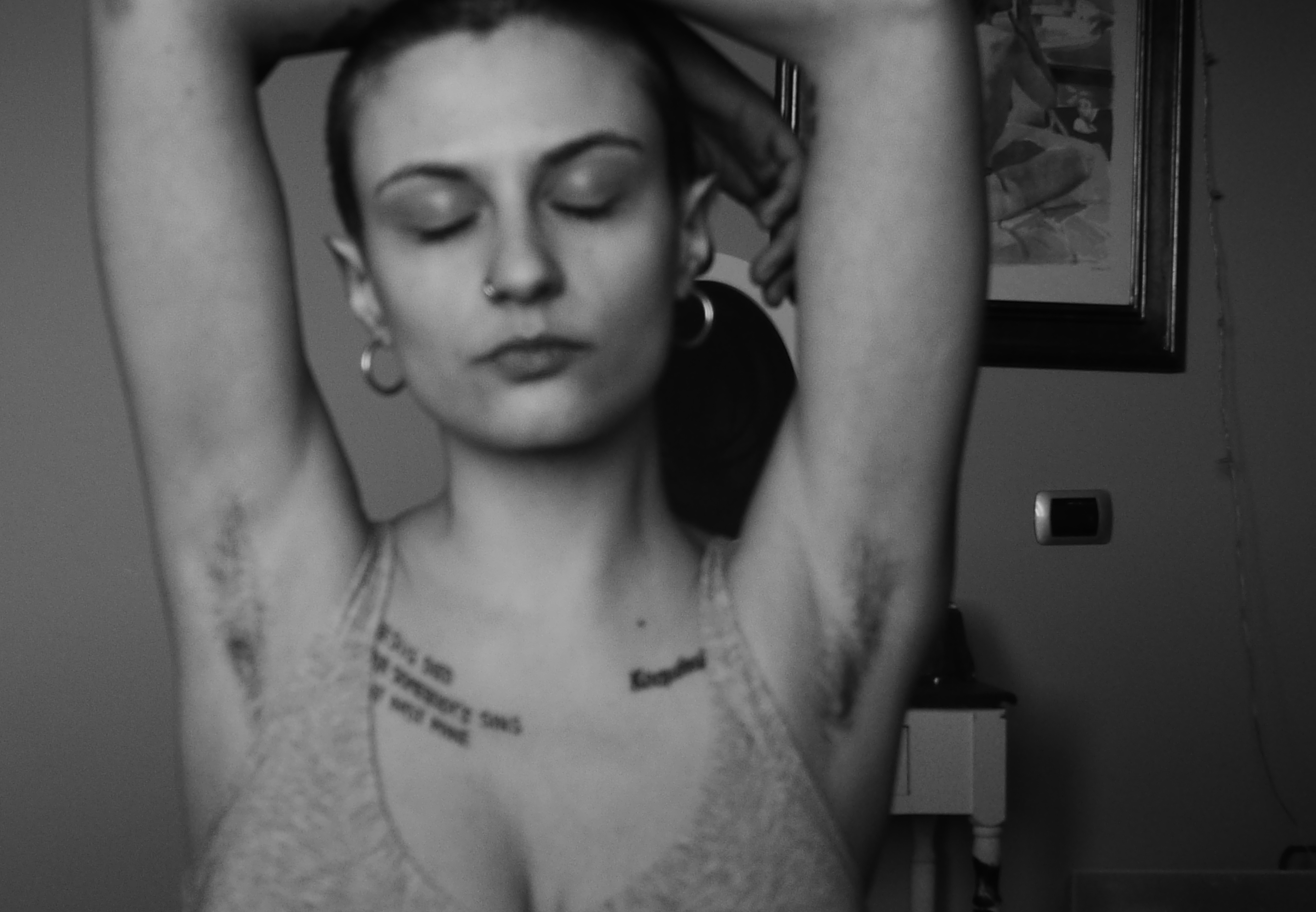 ragazza tatuata e rasata con piercing al naso e orecchini a cerchio