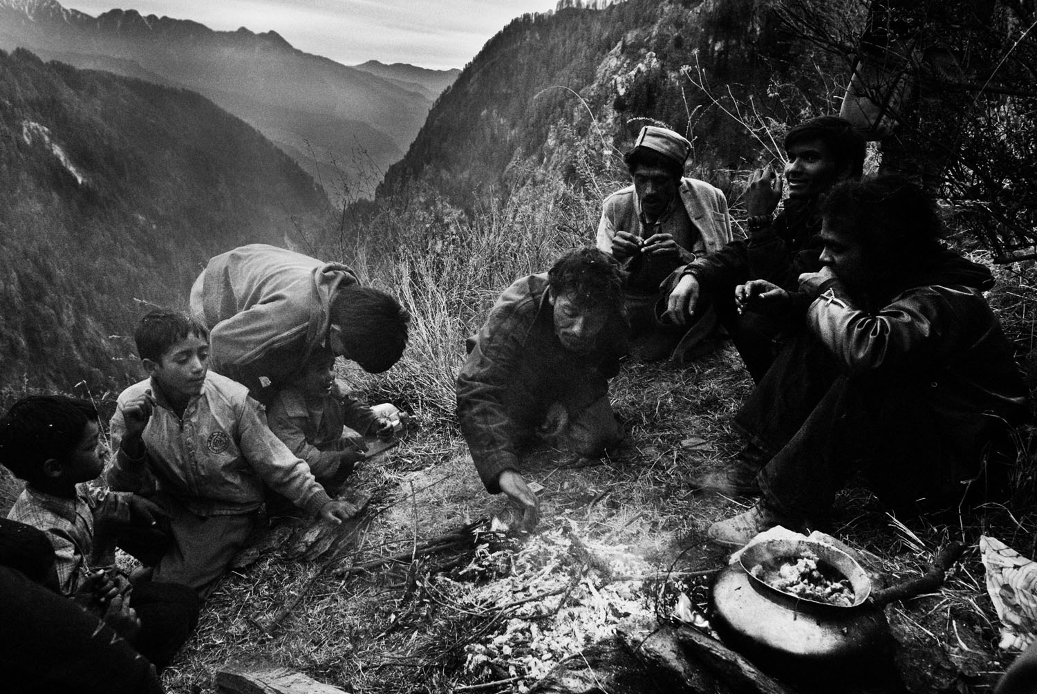 Sekelompok laki-laki mengadakan pesta bakar makanan di atas bukit