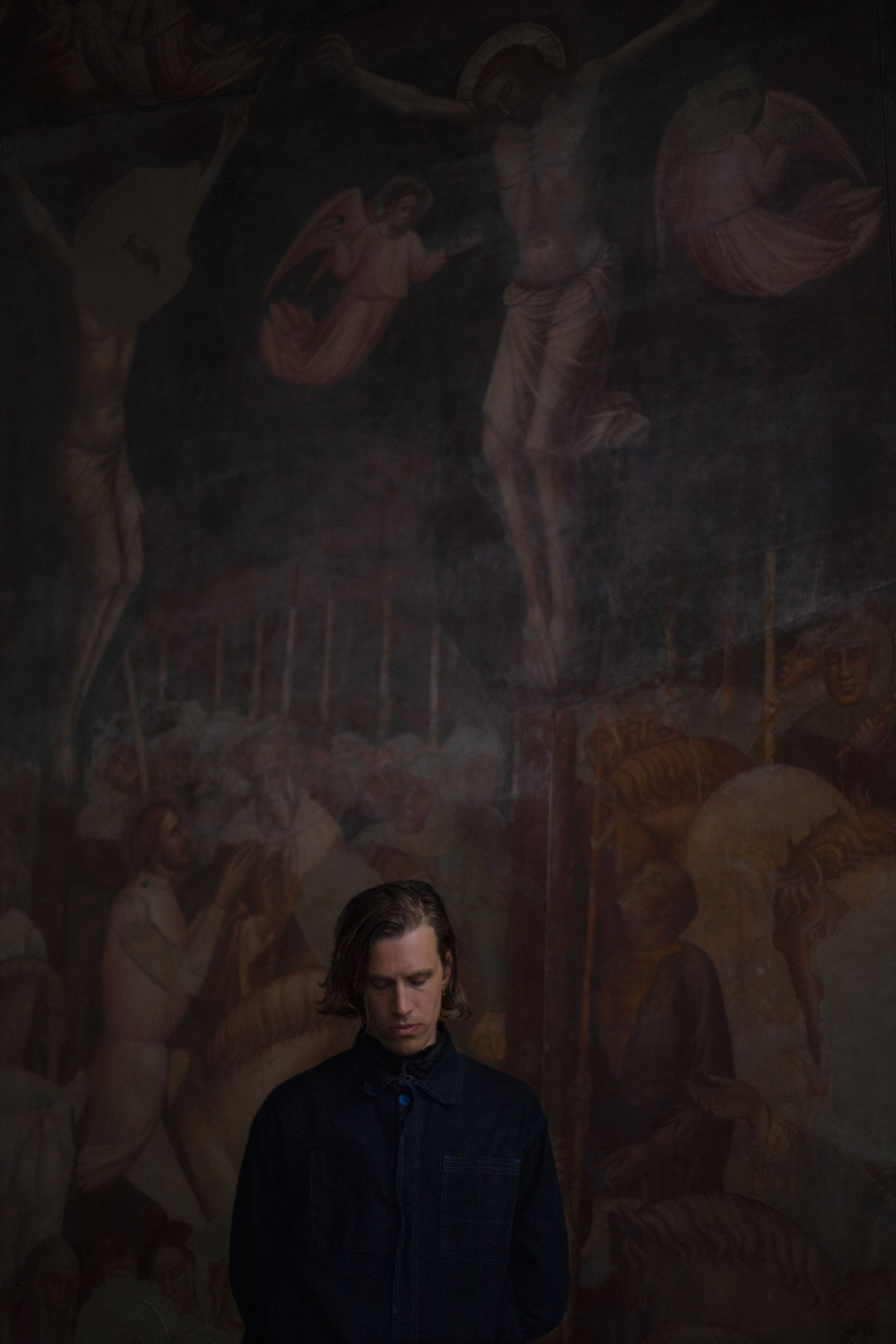 uomo con caschetto davanti ad affresco