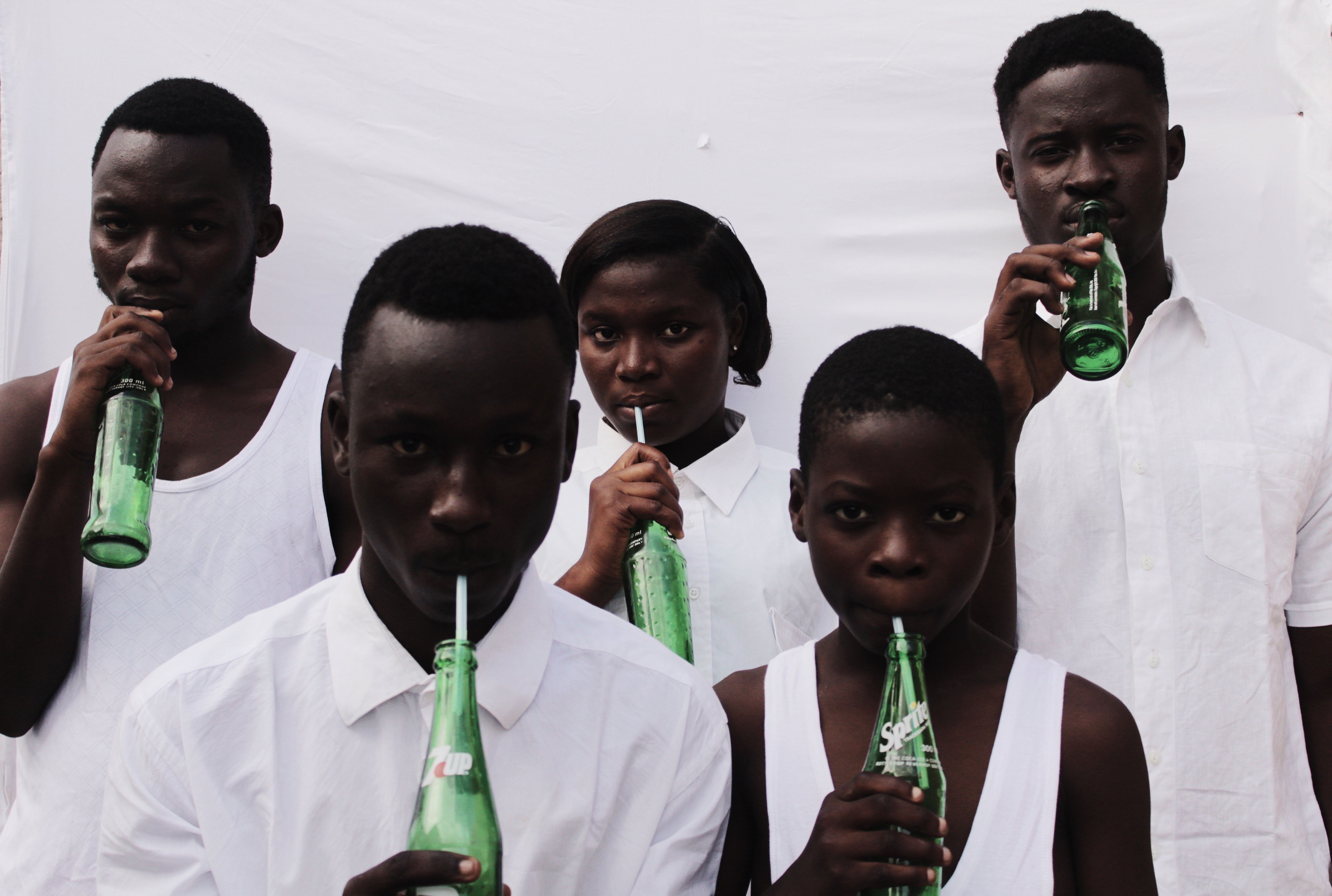 Five young people wearing white shirts and drinking 7up.