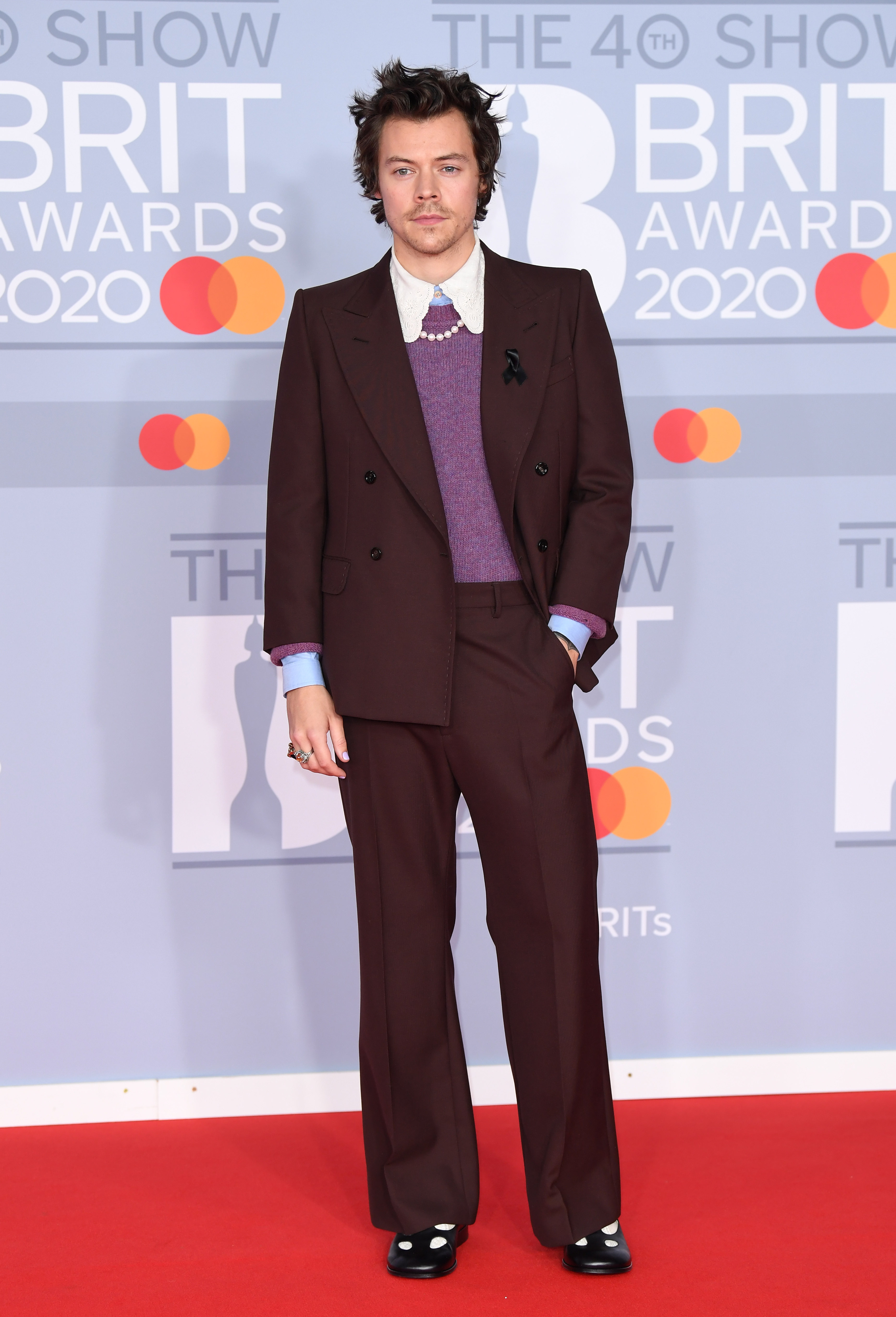 Harry Styles in a brown suit, lilac jumper, pearl necklace and maryjanes at the Brit awards 2020